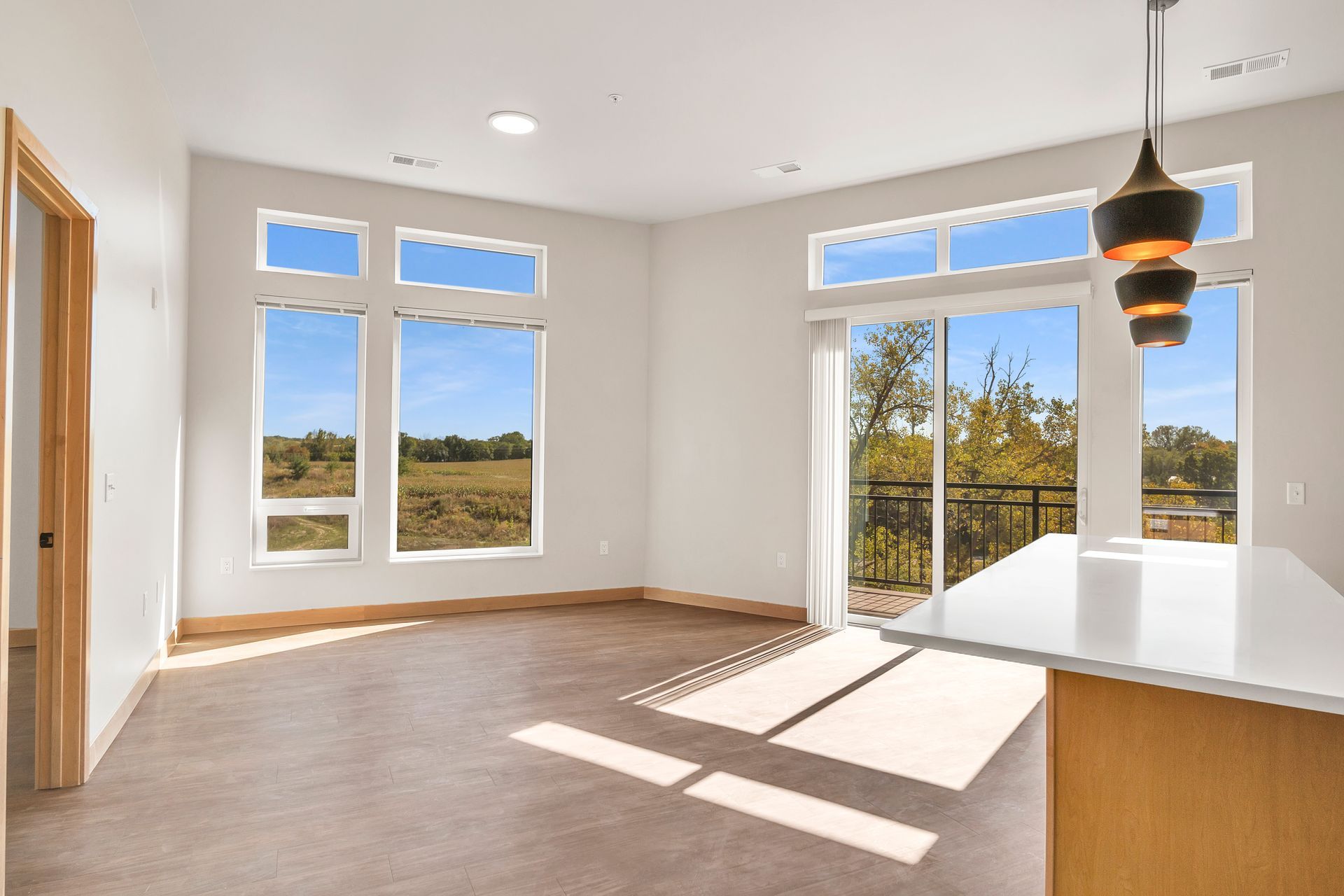 A living room with a lot of windows and a sliding glass door.