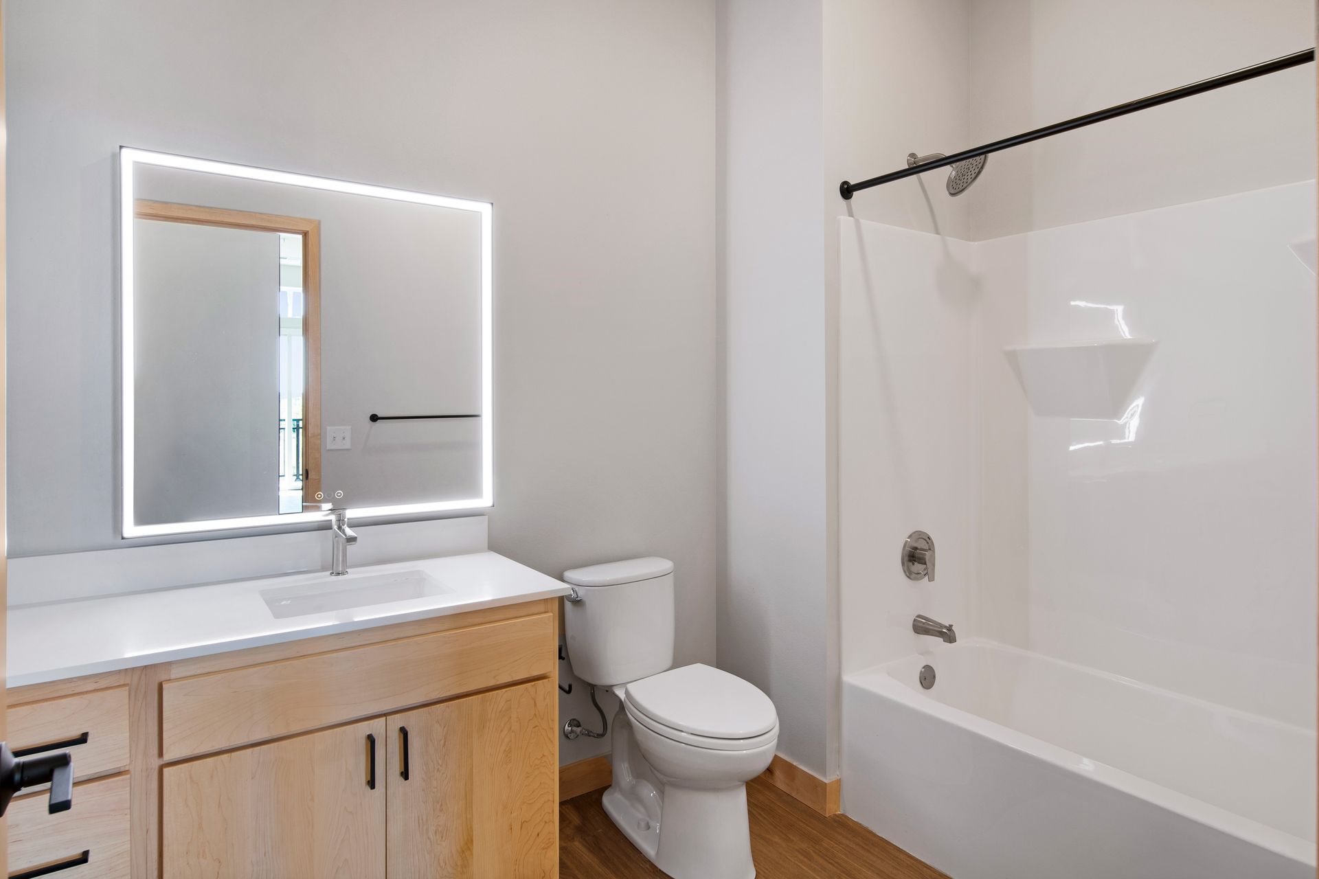 A bathroom with a toilet , sink , mirror and bathtub.