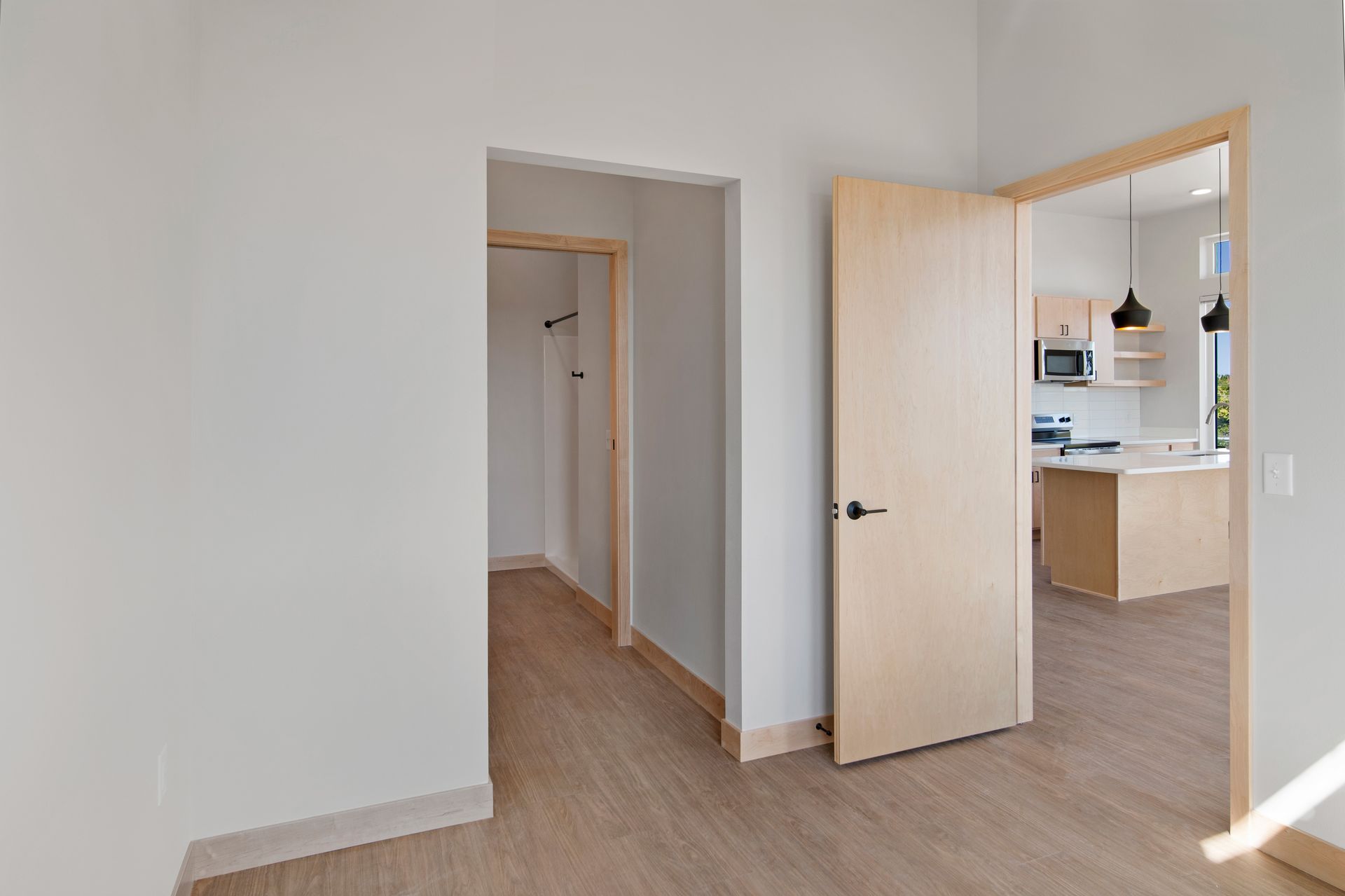 Doors leading to a kitchen and a closet in a bedroom.