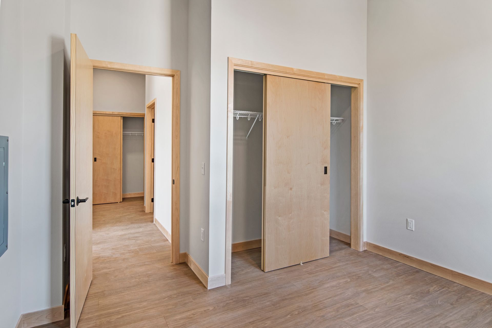 An empty bedroom with sliding doors leading to a closet.