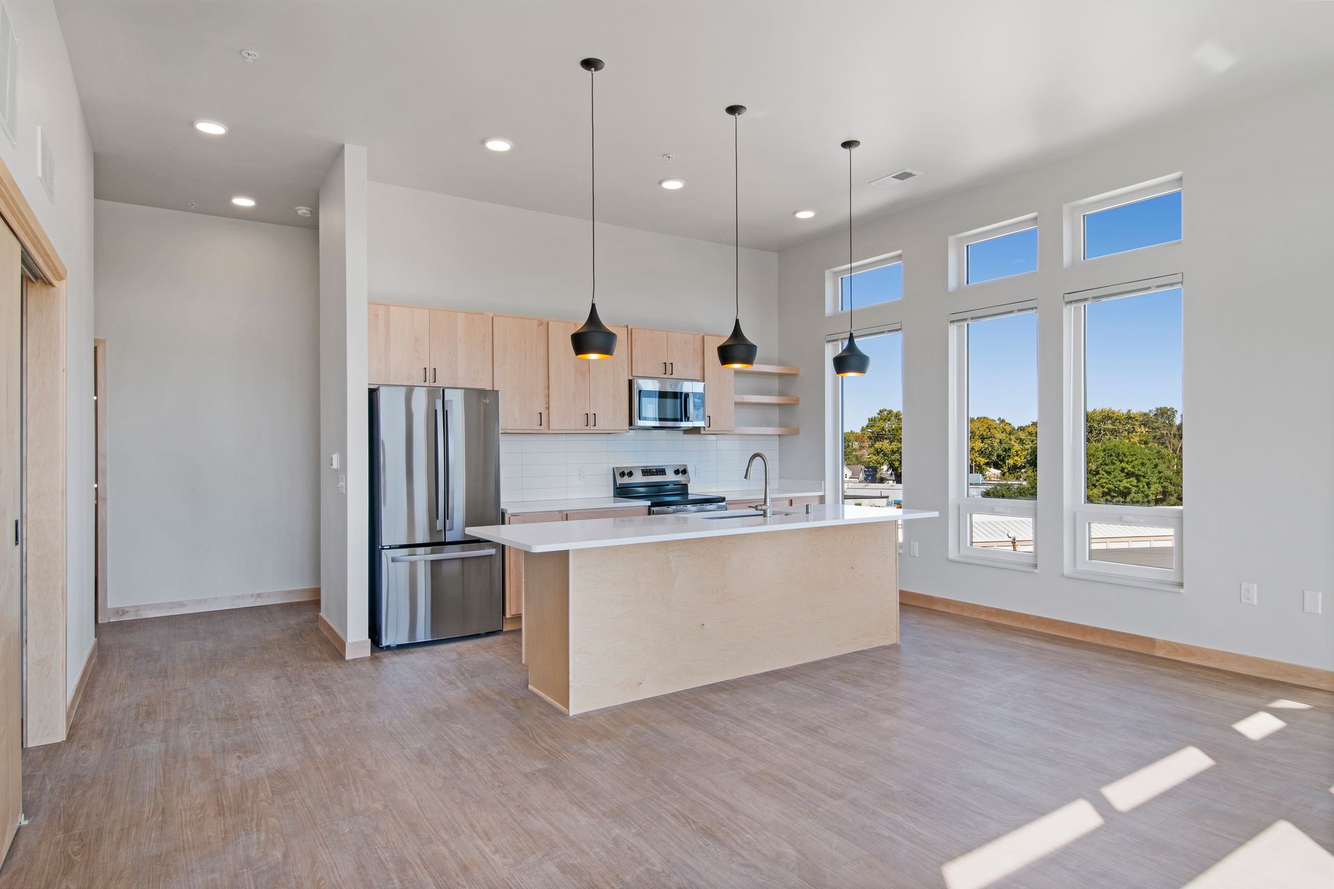 A kitchen with stainless steel appliances and a large island.