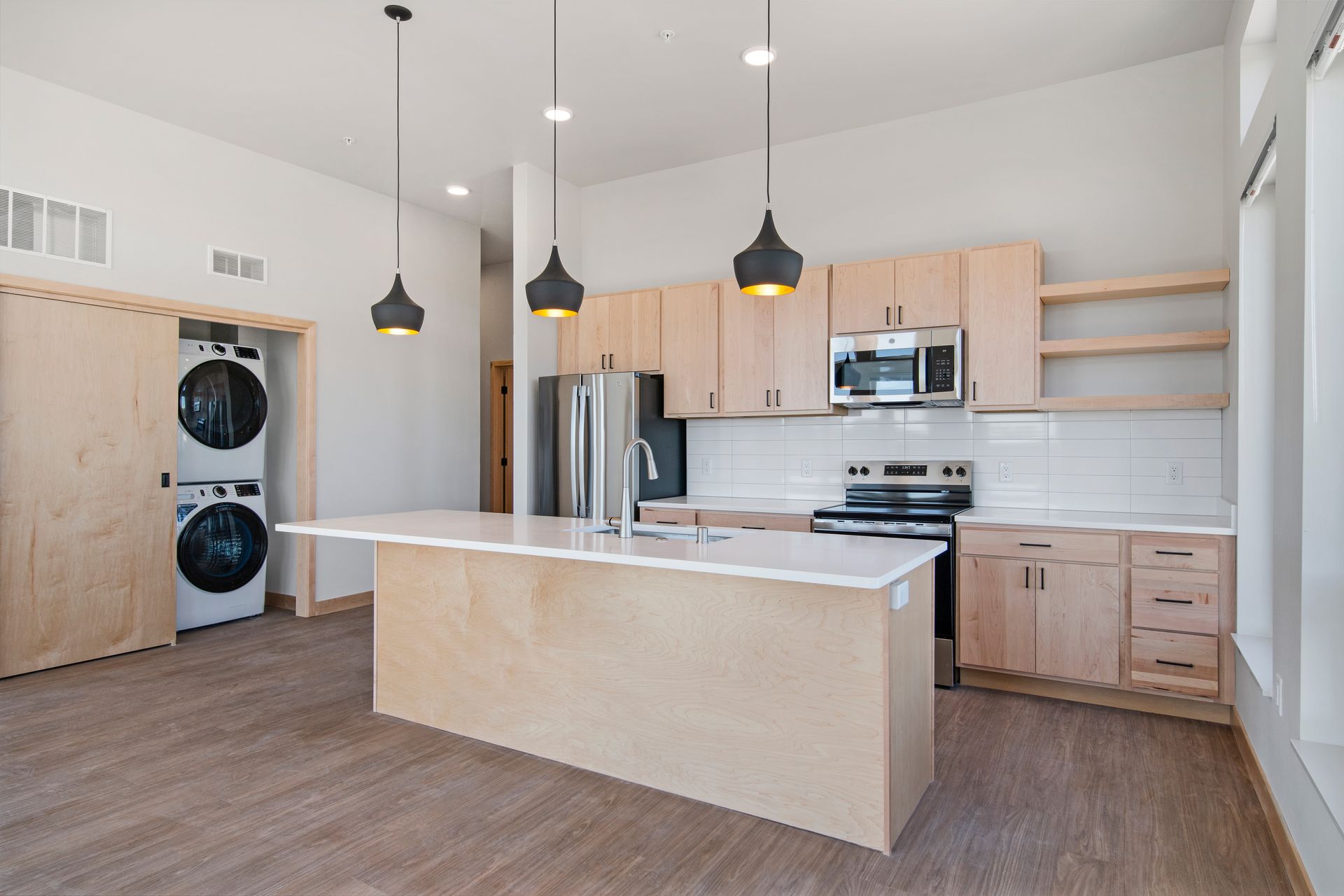 A kitchen with wooden cabinets , stainless steel appliances , and a large island.