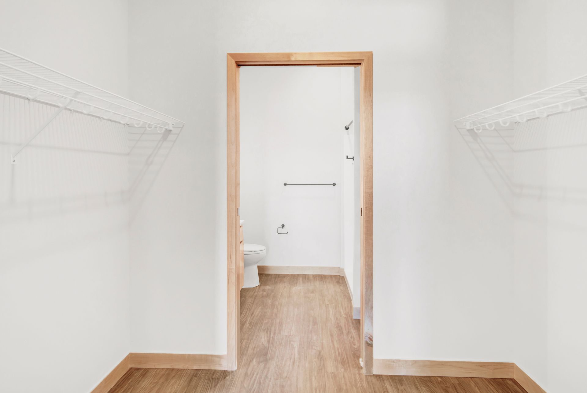 A walk in closet with a toilet and a shower.