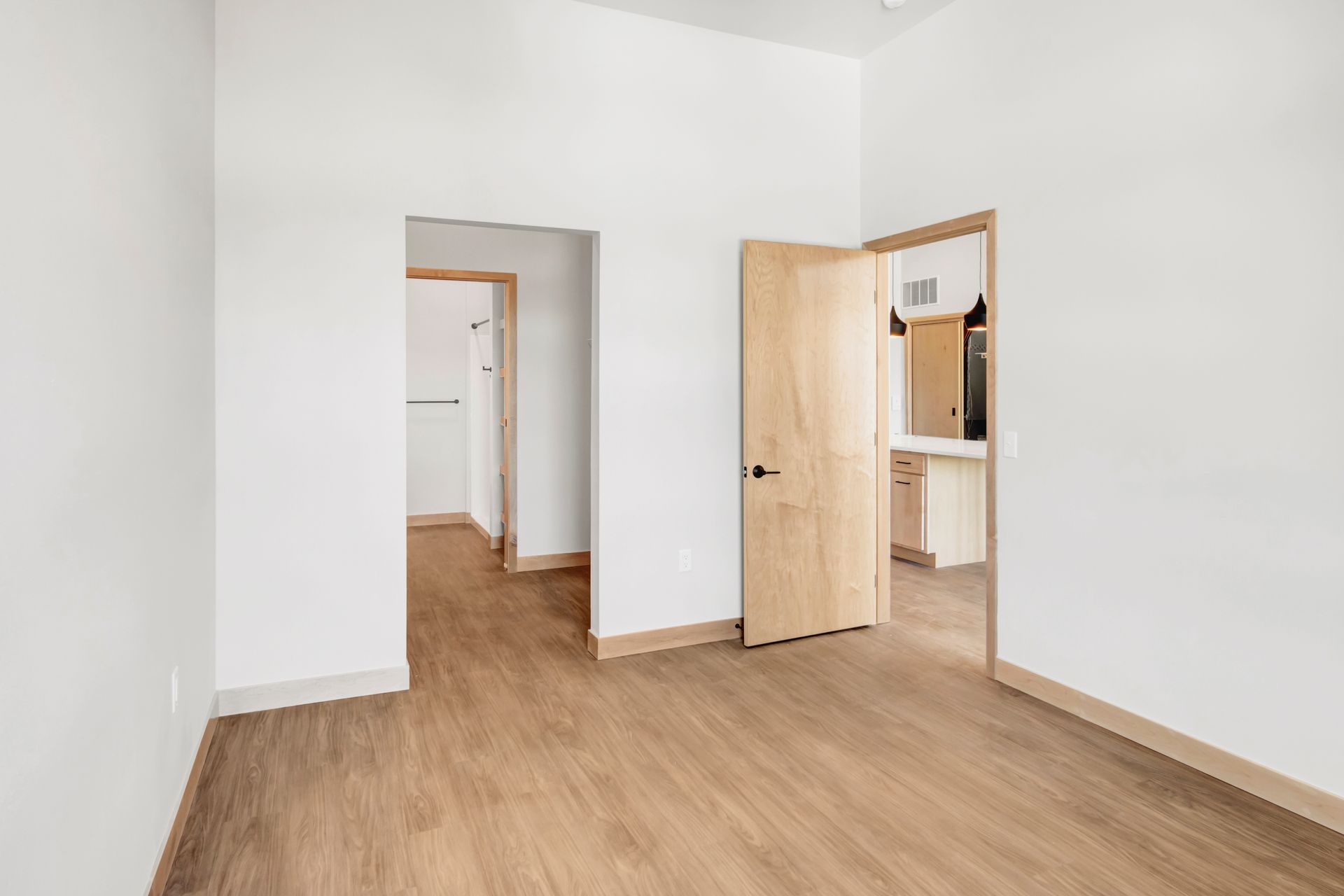 An empty room with wooden floors and white walls.