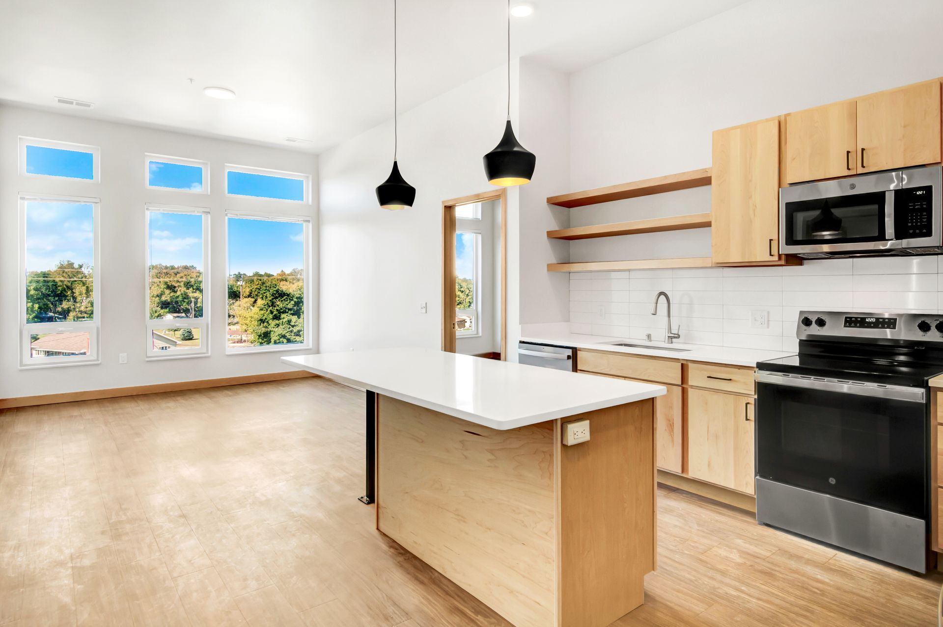 A kitchen with wooden cabinets , stainless steel appliances , and a large island.
