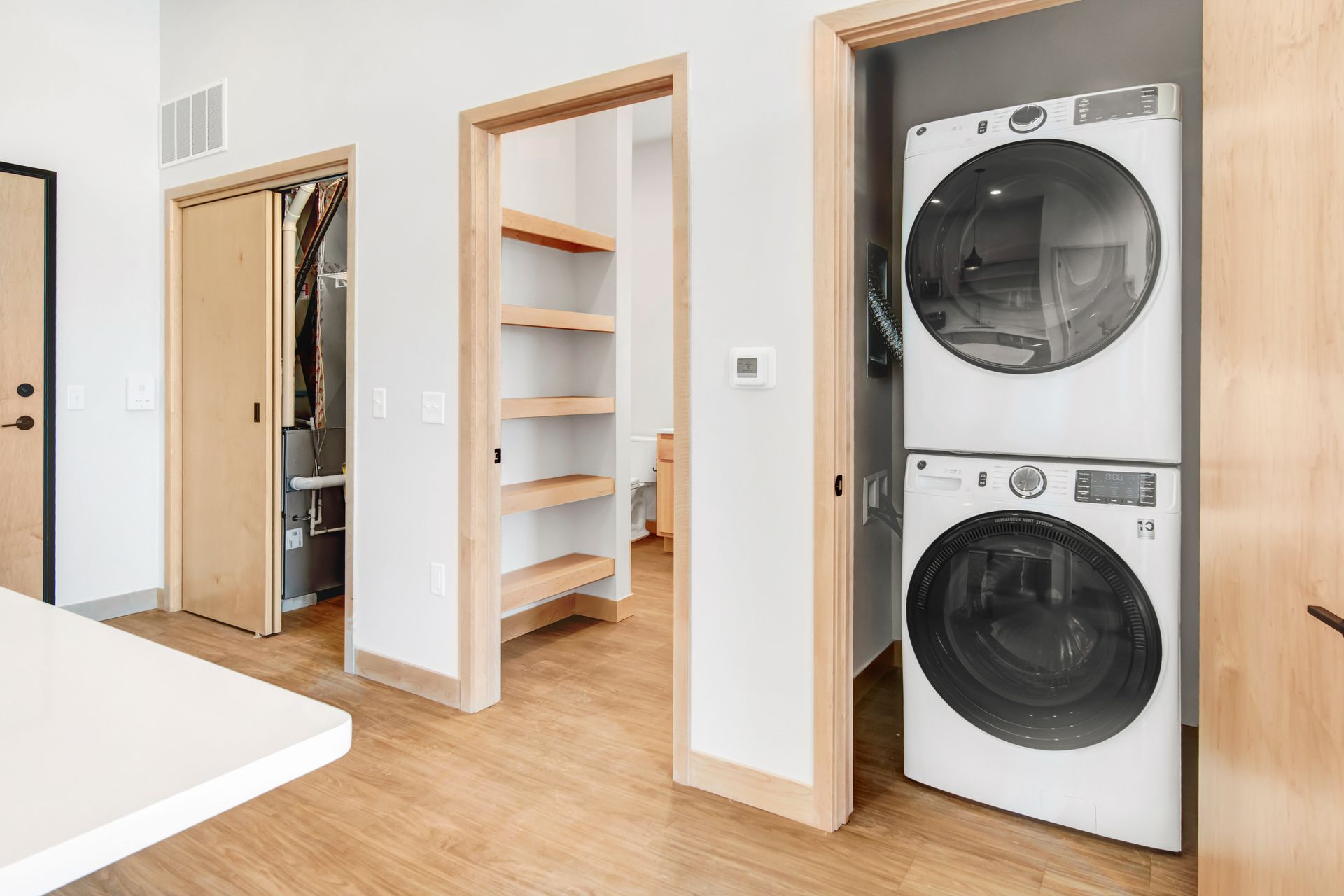 A washer and dryer are stacked on top of each other in a laundry room.