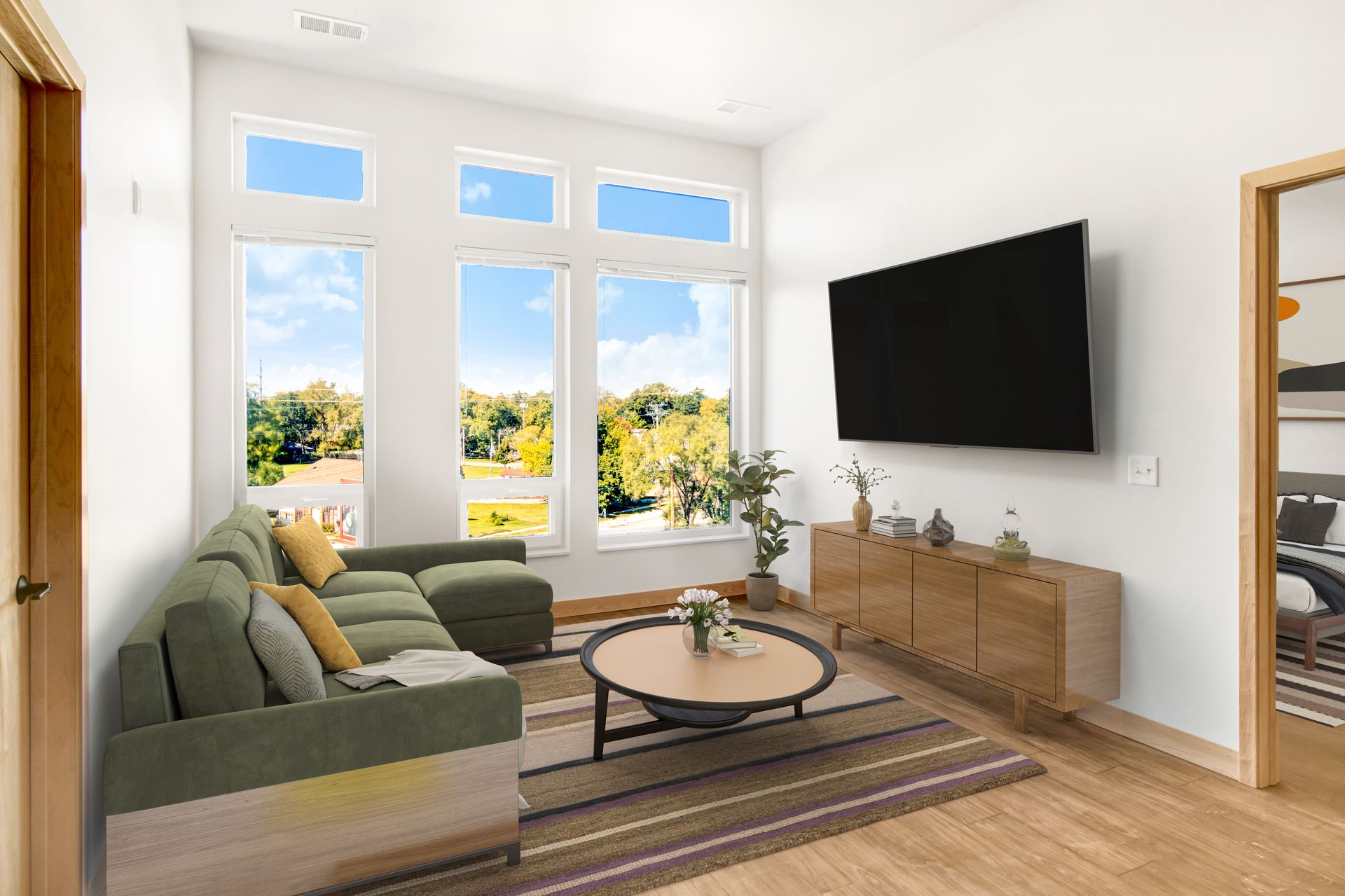 A living room with a couch and a flat screen tv on the wall.