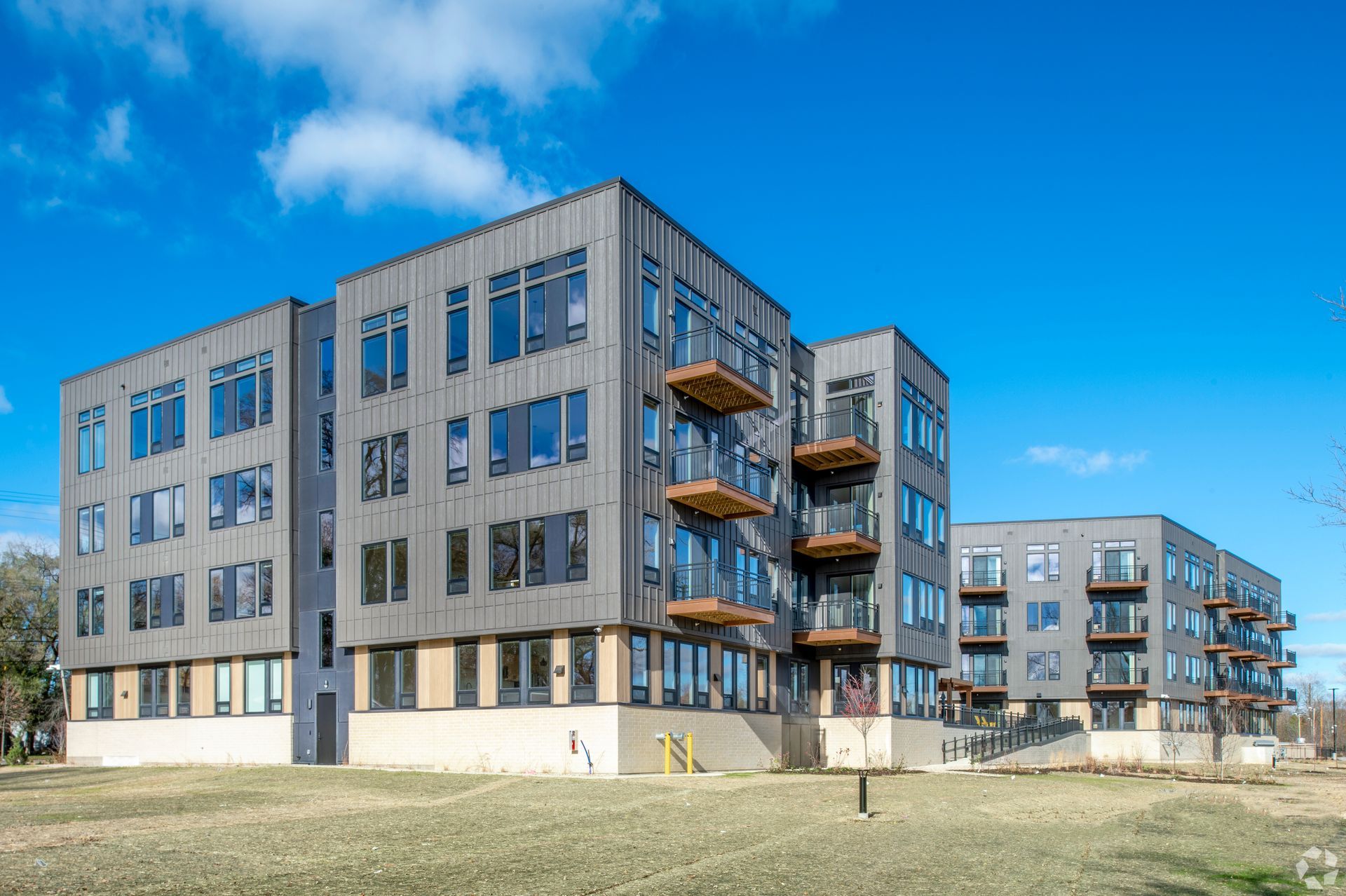 A large apartment building with a lot of windows and balconies on a sunny day.