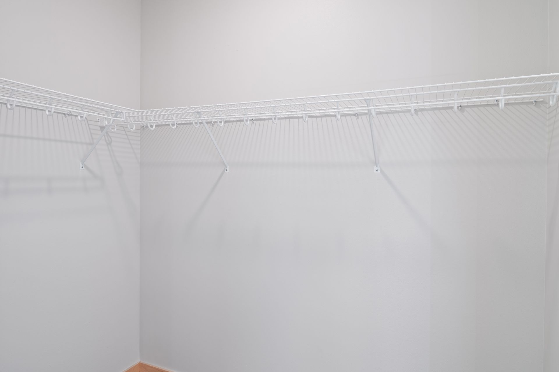 An empty walk-in closet with white wire shelves.