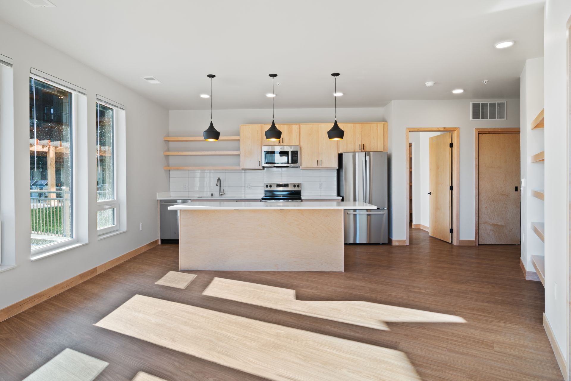 A kitchen with stainless steel appliances and a large island in the middle of the room.