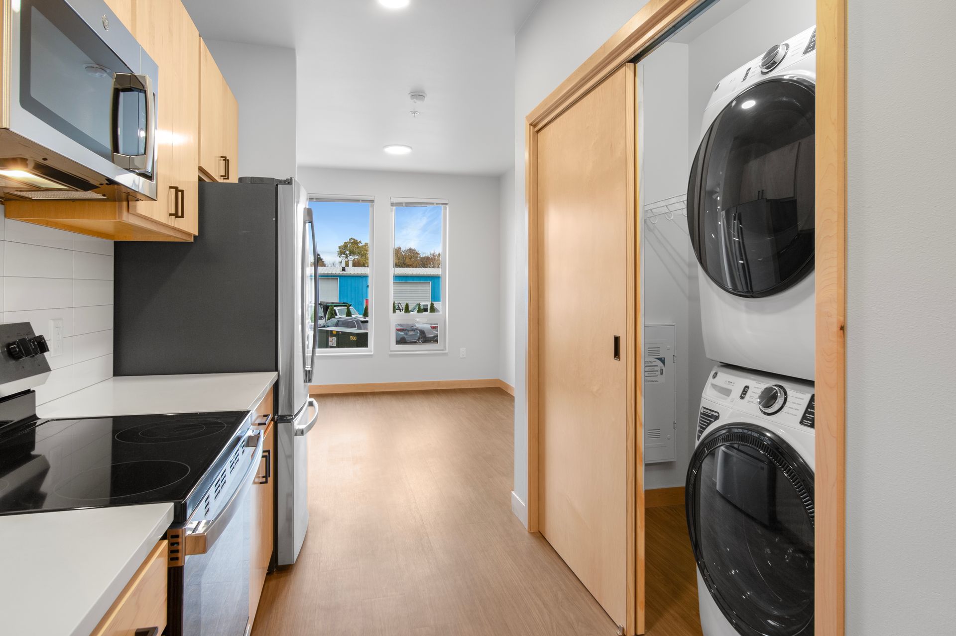 A kitchen with a washer and dryer stacked on top of each other.