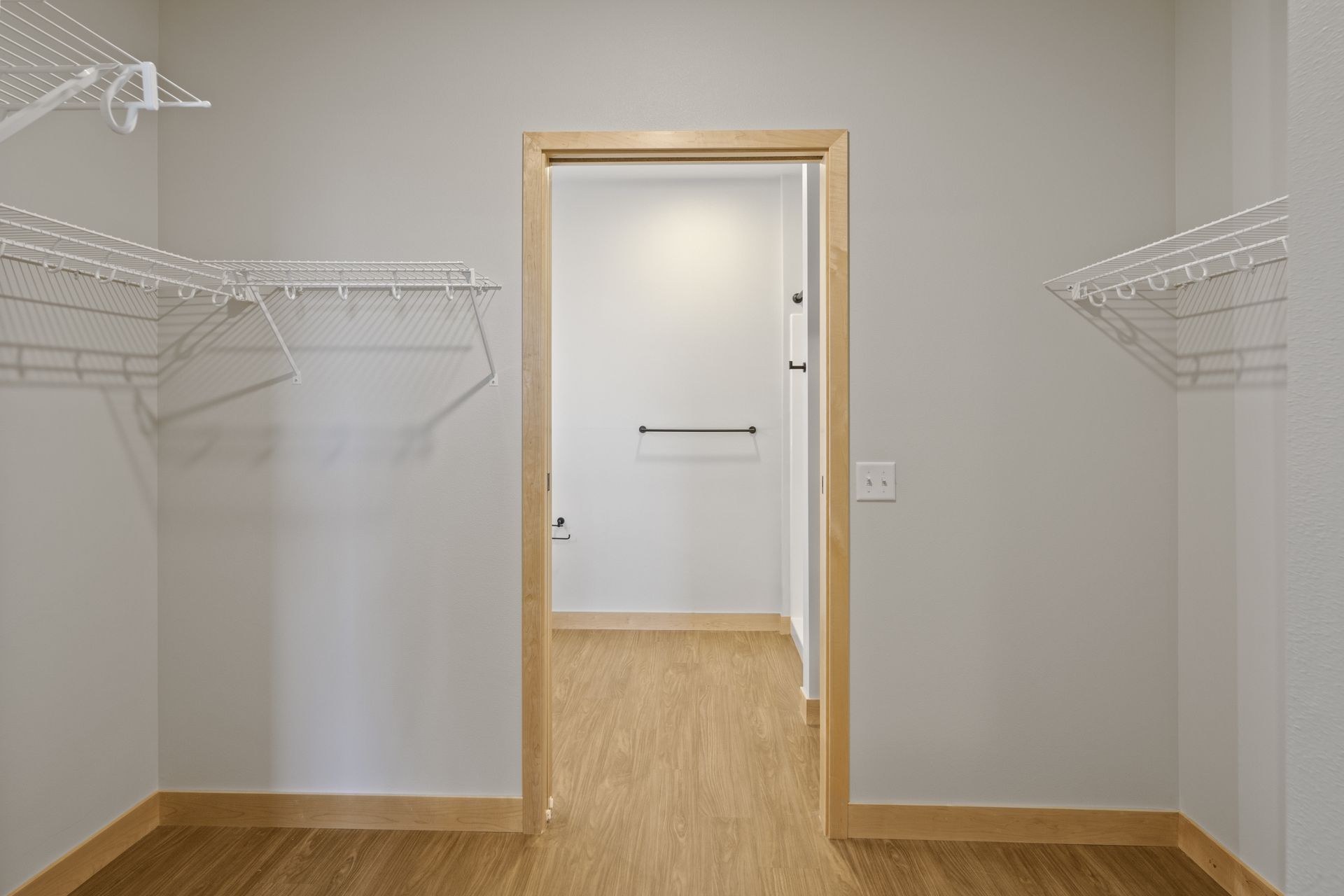 An empty walk-in closet with lvp  floors and a door.