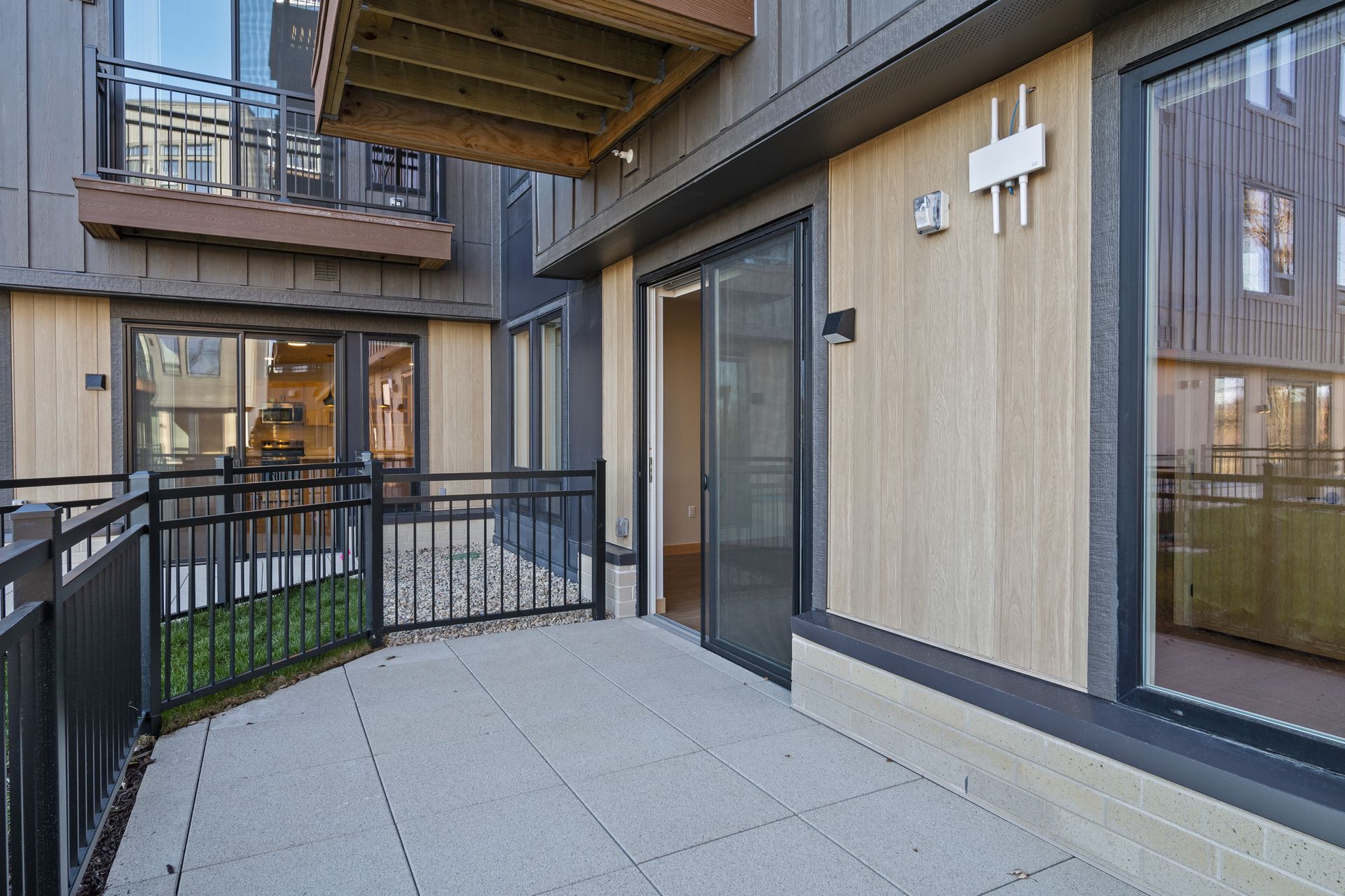 A patio with a fence and sliding glass doors.