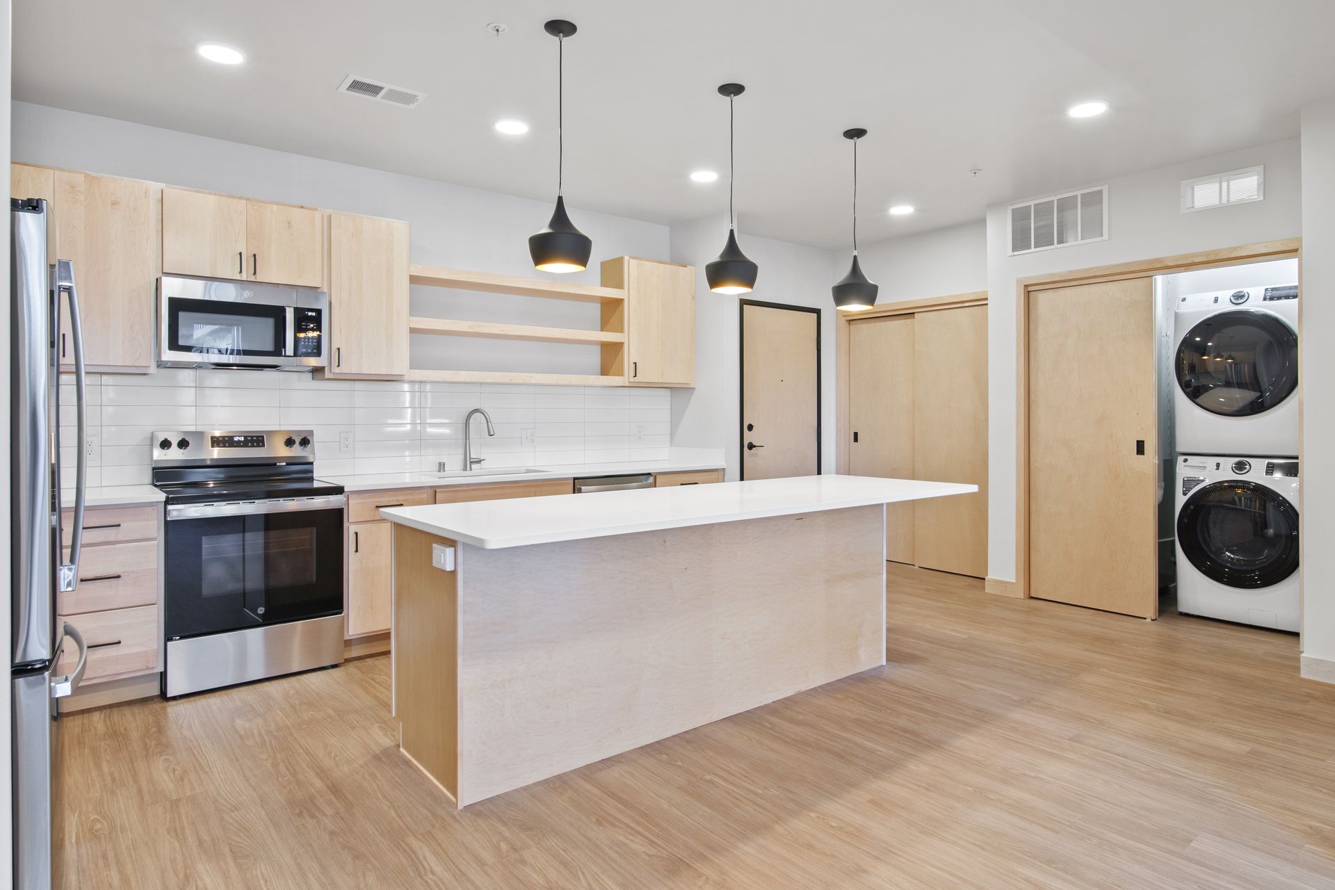 A kitchen with a large island and stainless steel appliances.