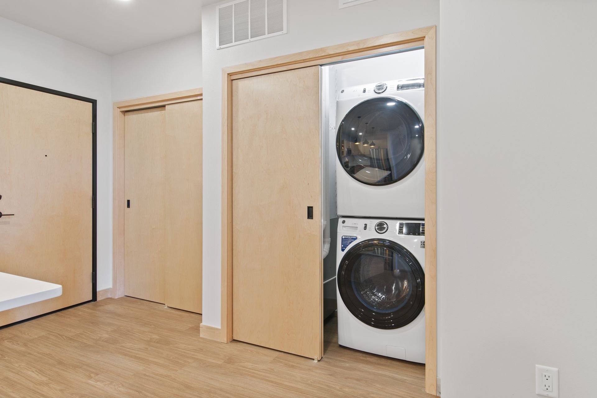 A washer and dryer are stacked on top of each other in a closet.
