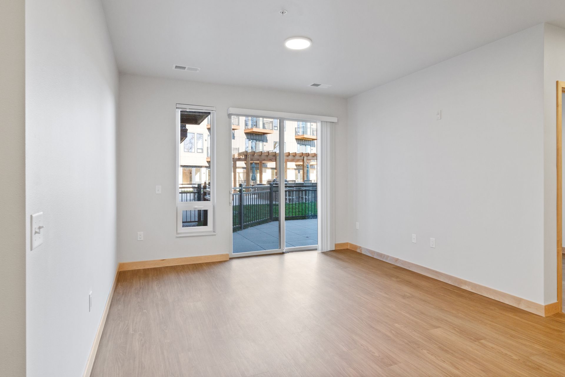 Spacious living room with lvp floors and sliding glass doors leading to a patio.
