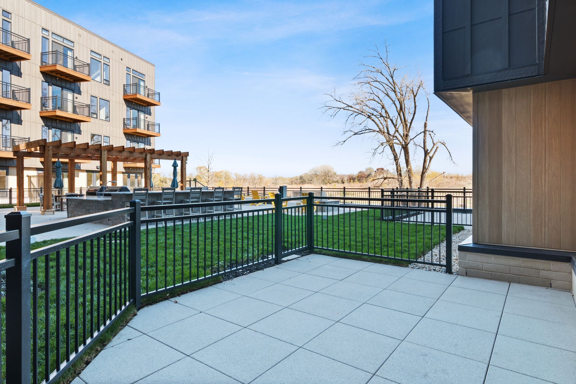 A patio large fenced in patio and a building in the background.