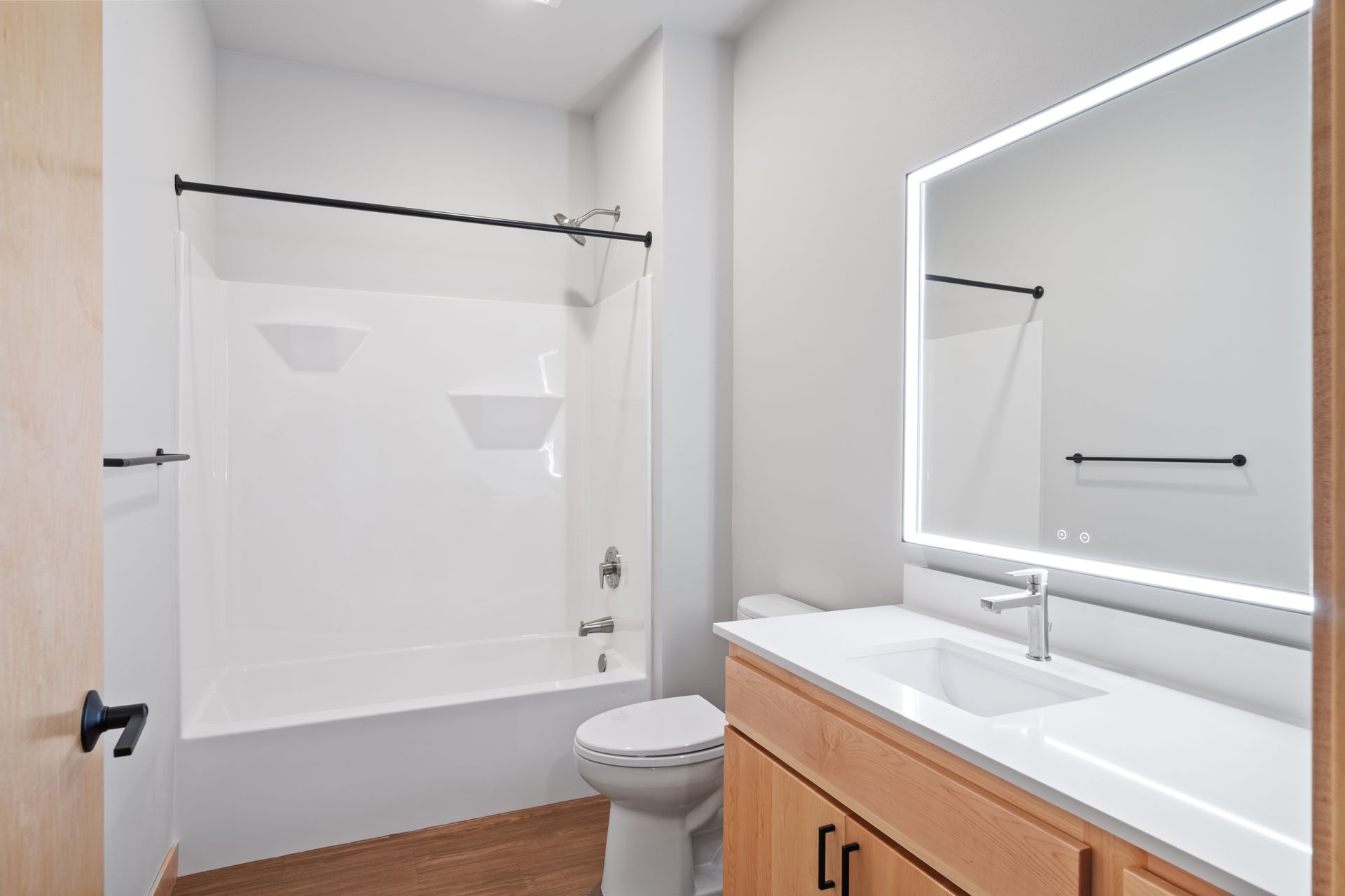 A bathroom with a toilet , sink , shower and mirror.