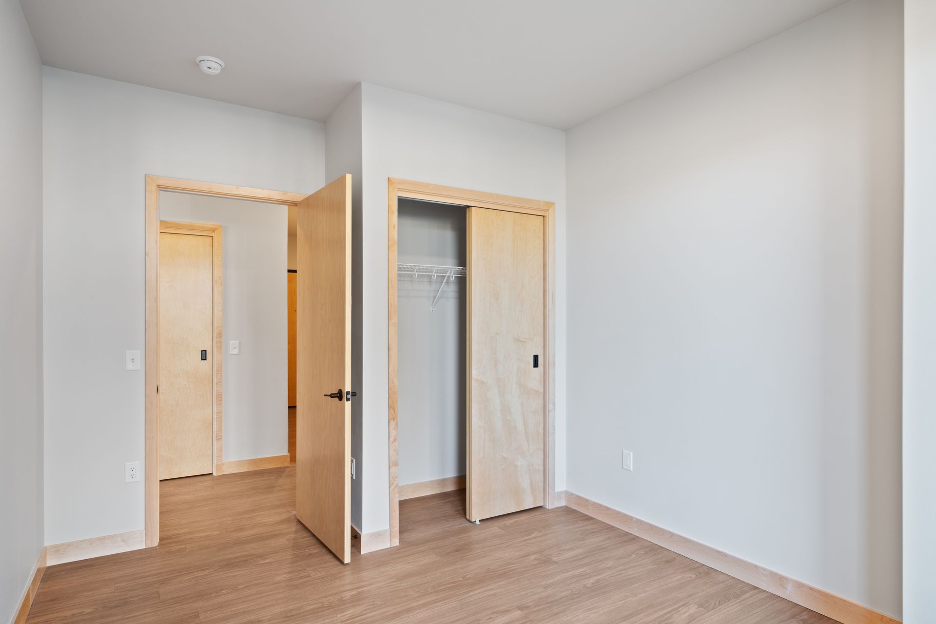 Empty bedroom with open closet.