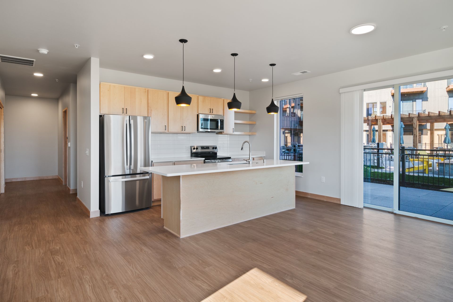 An open kitchen with stainless steel appliances and a large island.