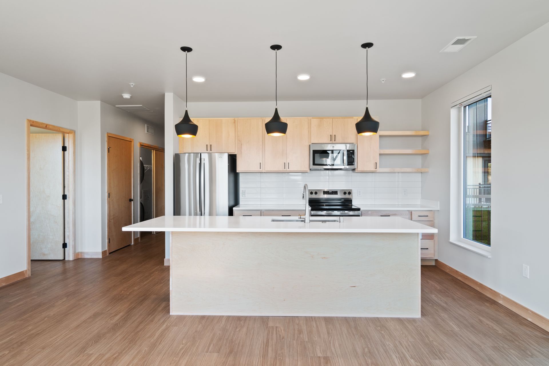 An open kitchen with stainless steel appliances and a large island.