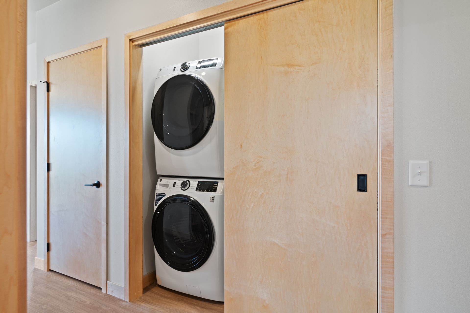 A washer and dryer are stacked on top of each other in a closet.