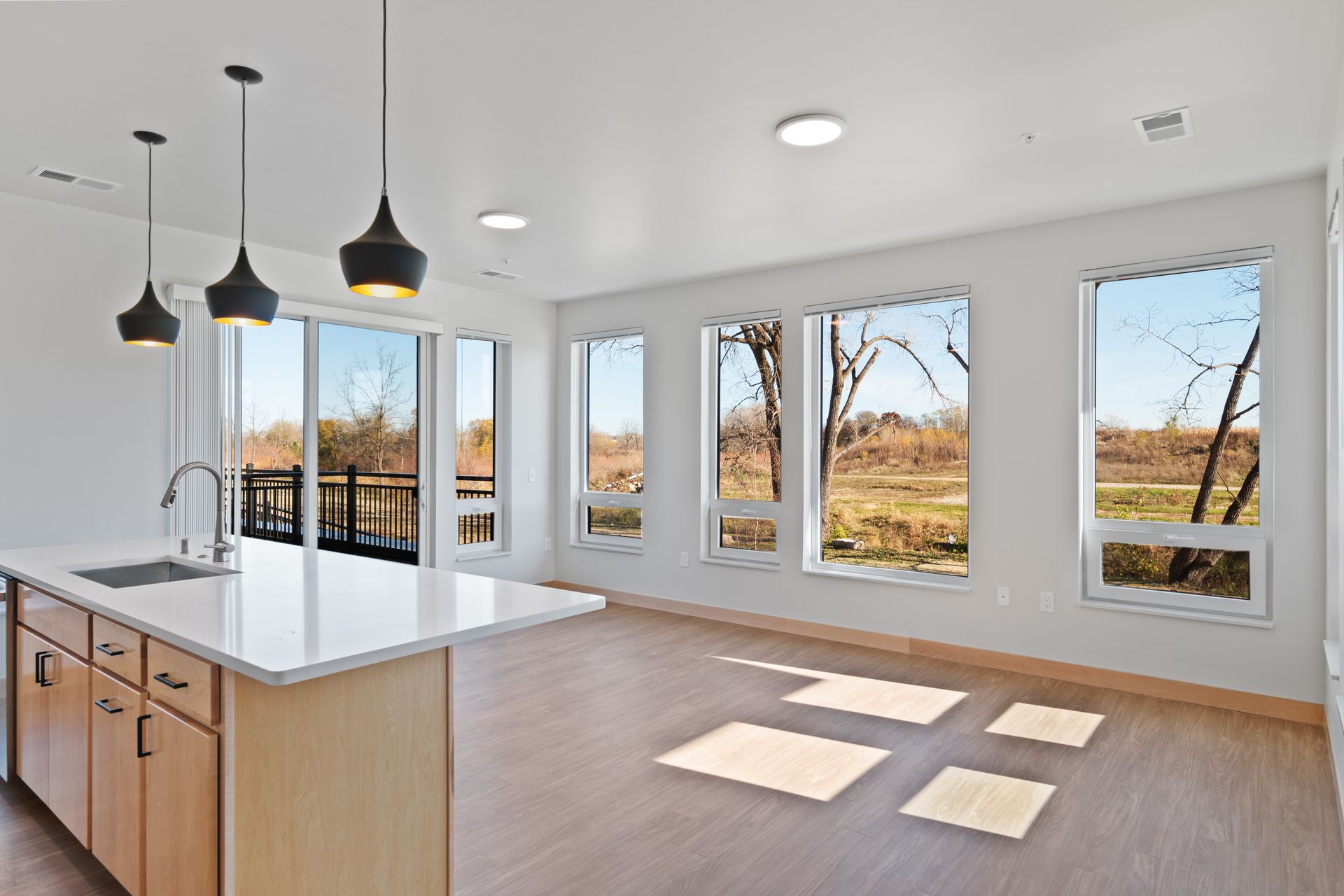 A kitchen with a large island and lots of windows.