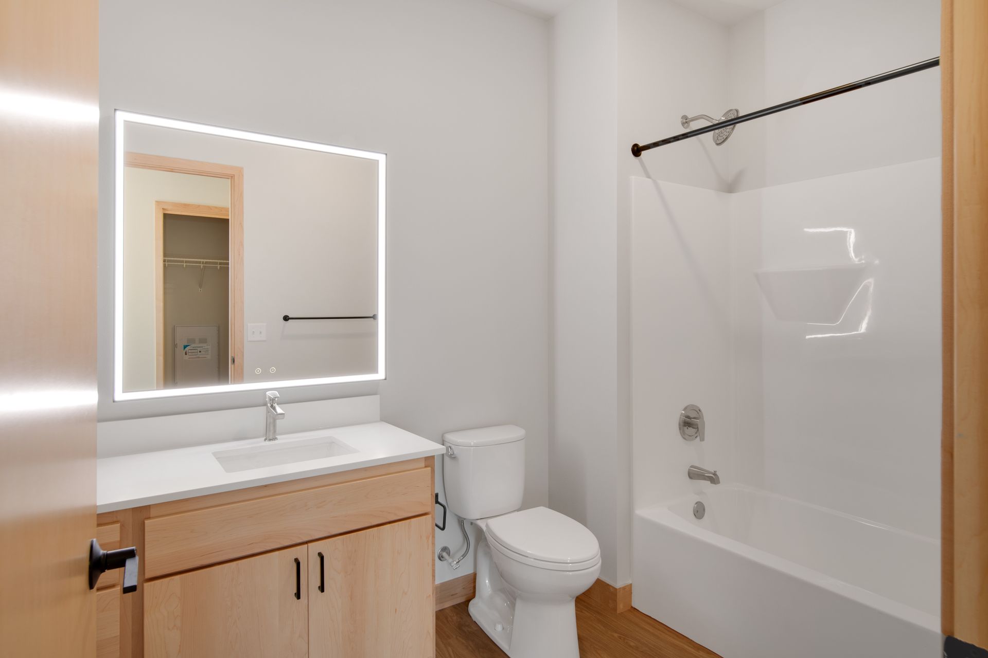 A bathroom with a toilet , sink , mirror and bathtub.