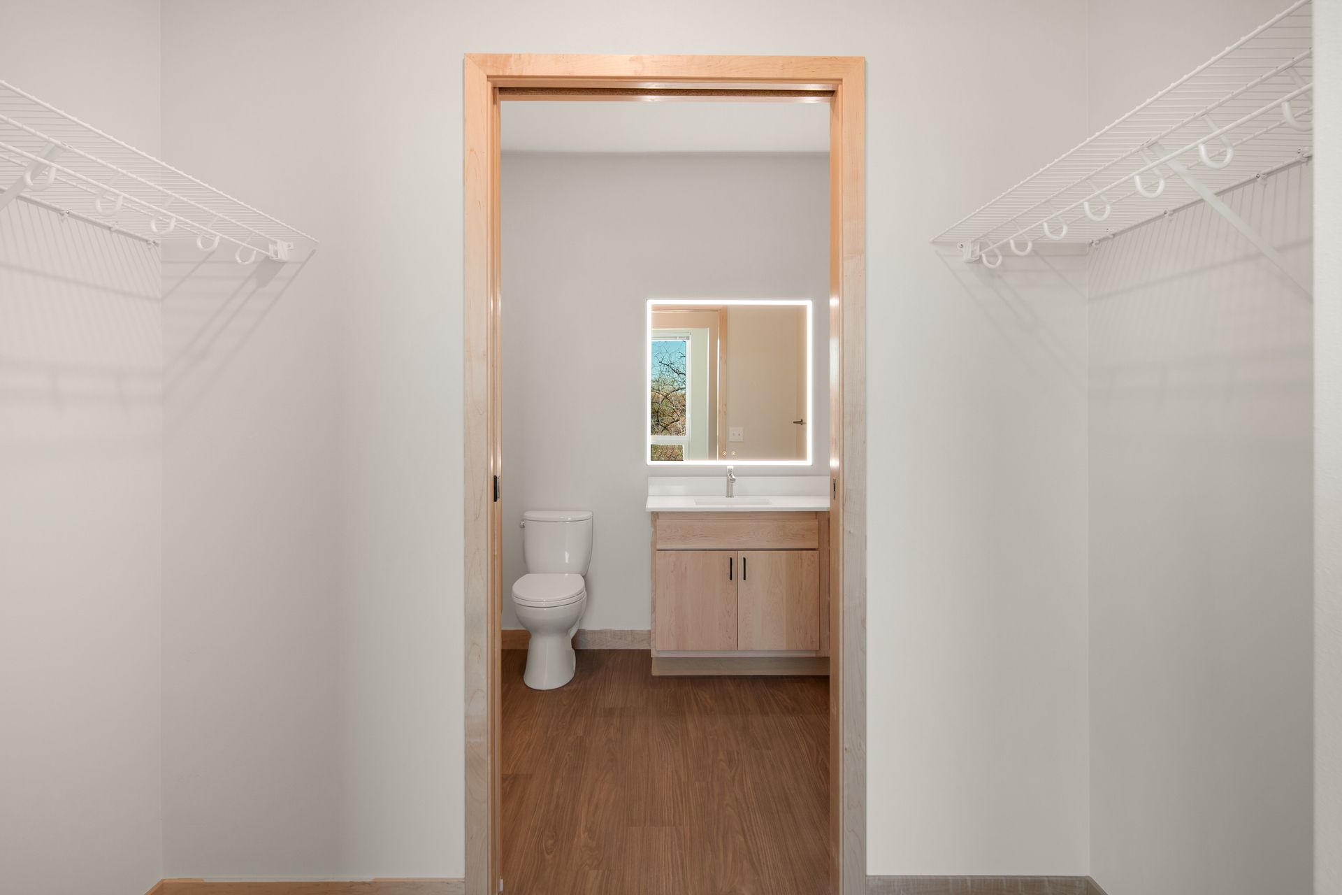 A bathroom with a toilet , sink and mirror.