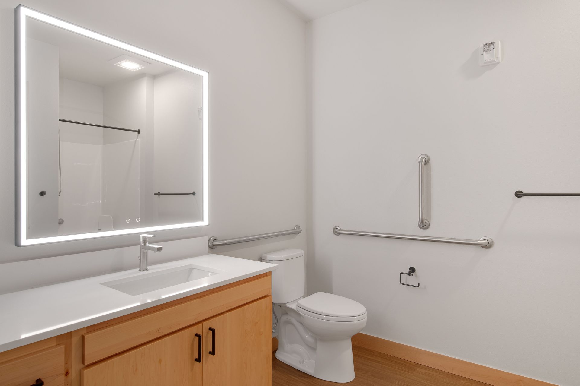 A bathroom with a toilet , sink and mirror.