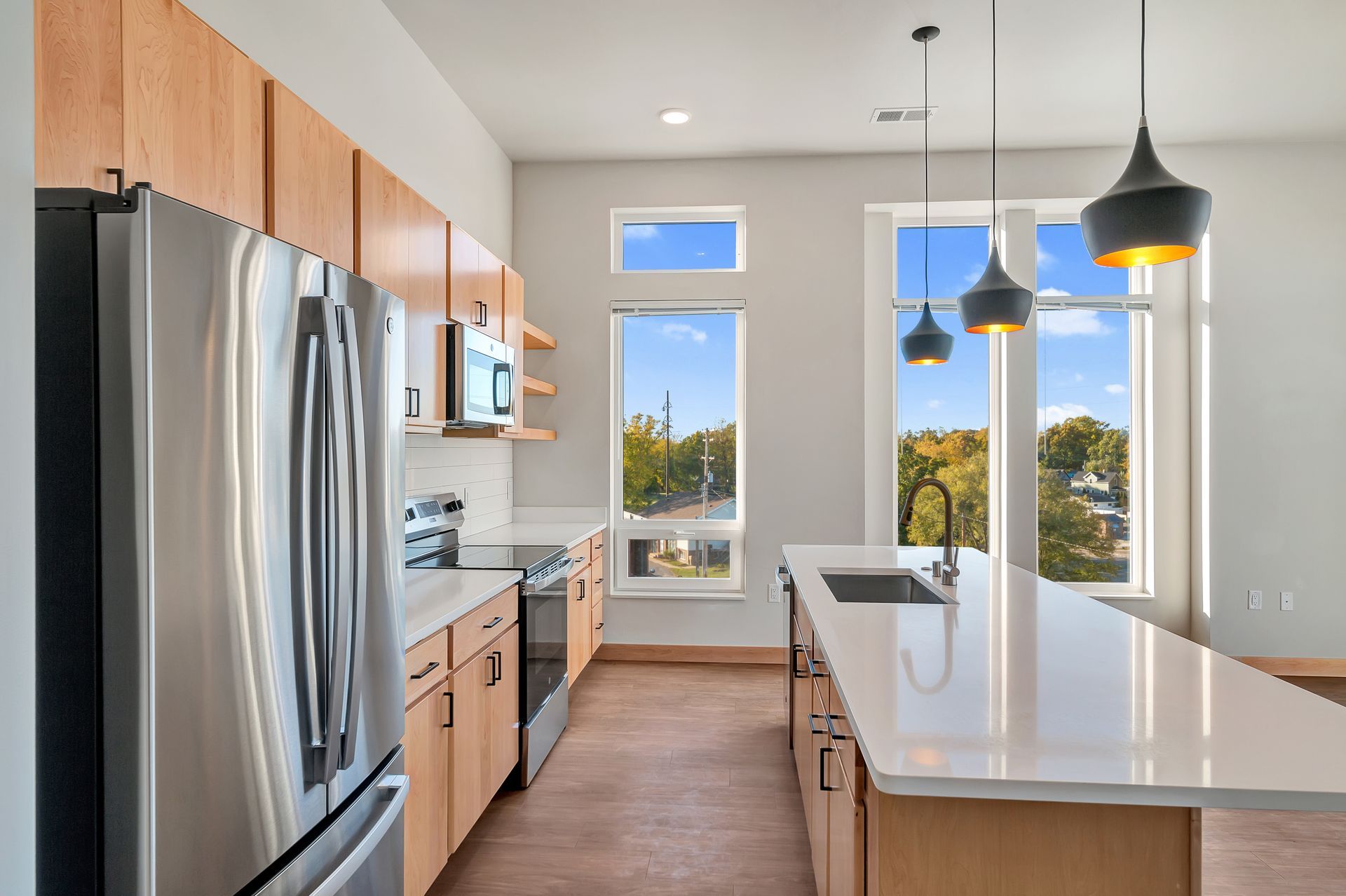A kitchen with stainless steel appliances , wooden cabinets , and a large island.
