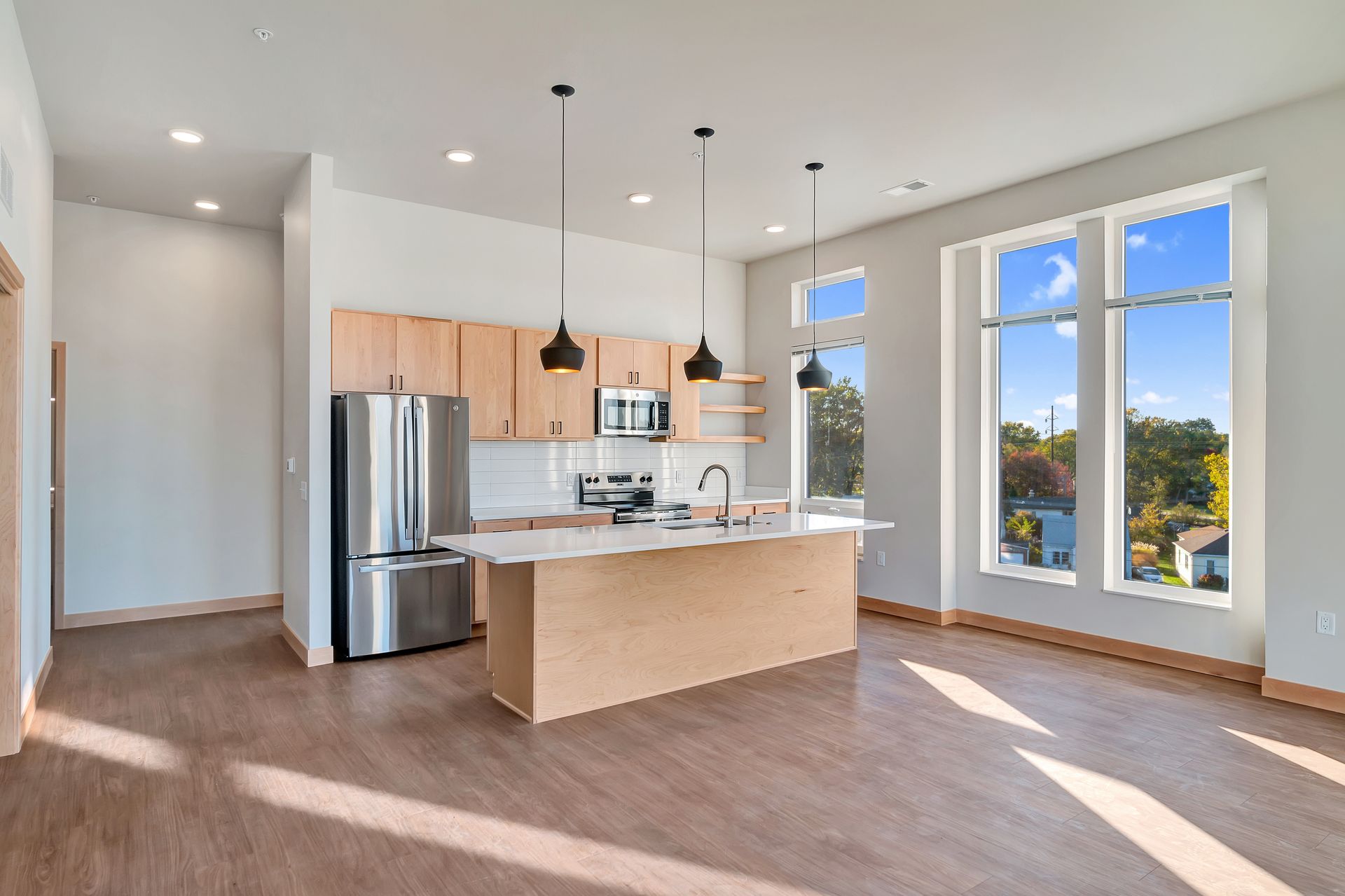 A kitchen with stainless steel appliances and a large island in the middle of the room.