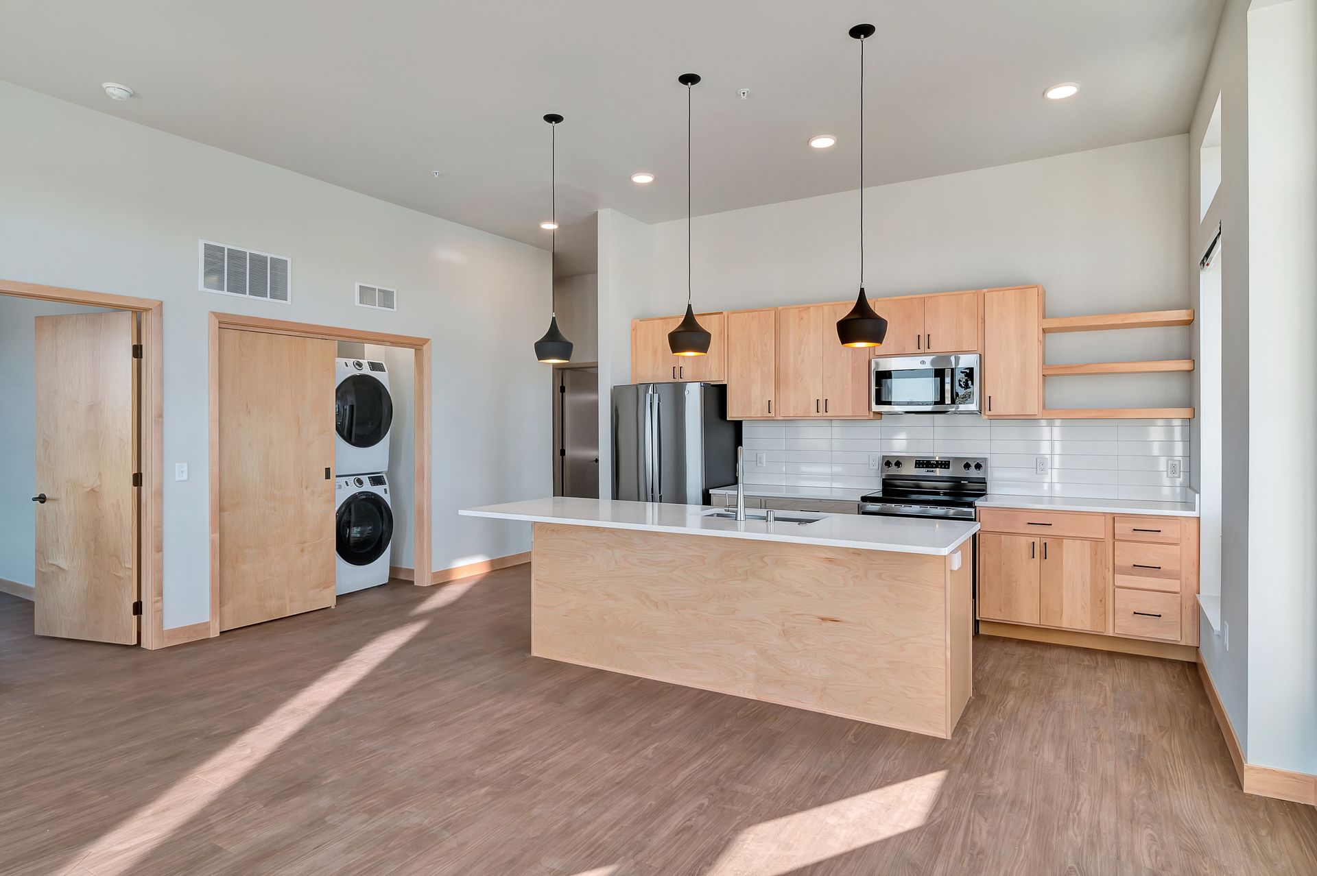 A kitchen with wooden cabinets , stainless steel appliances , and a large island.
