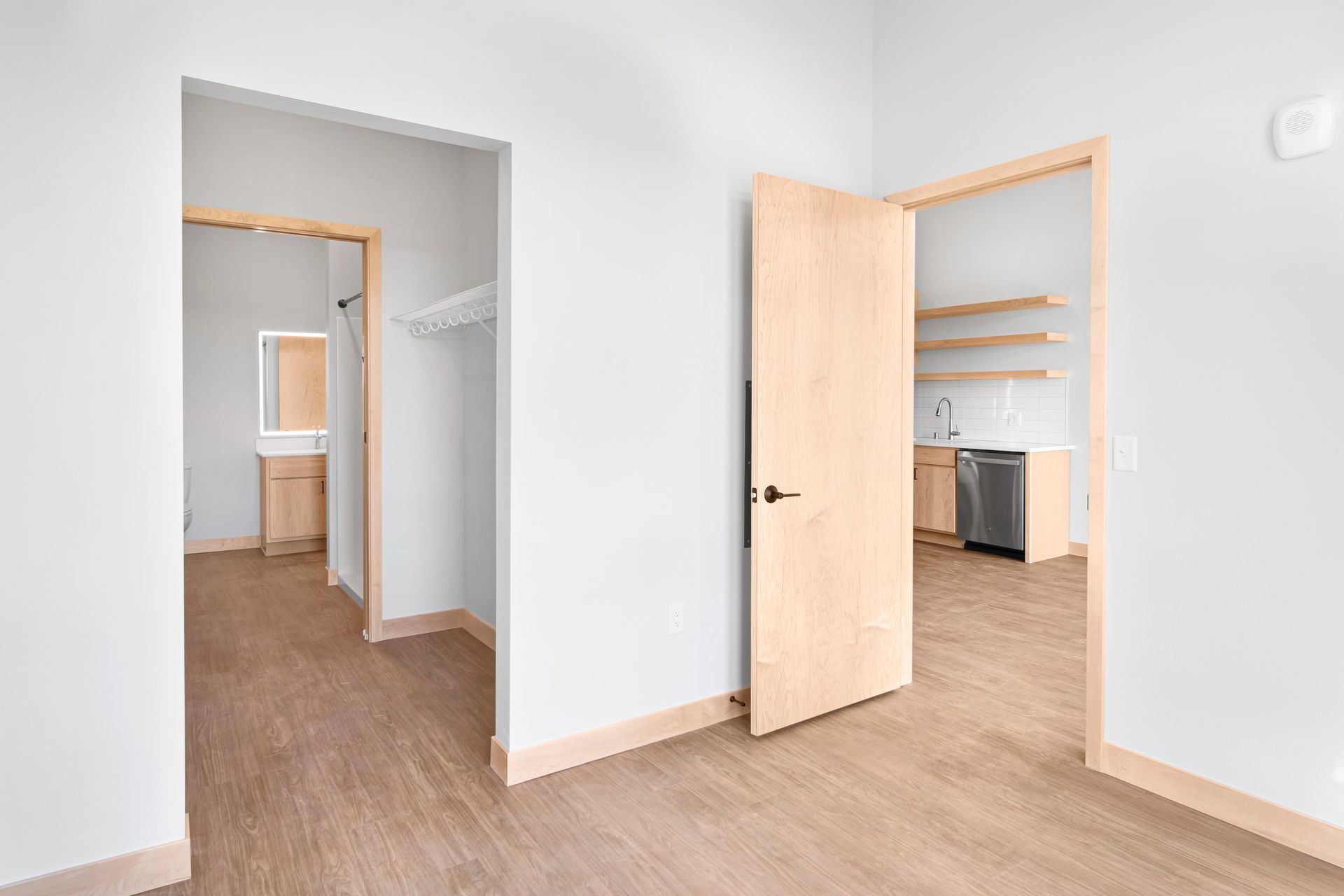 An empty room with wooden floors and white walls.