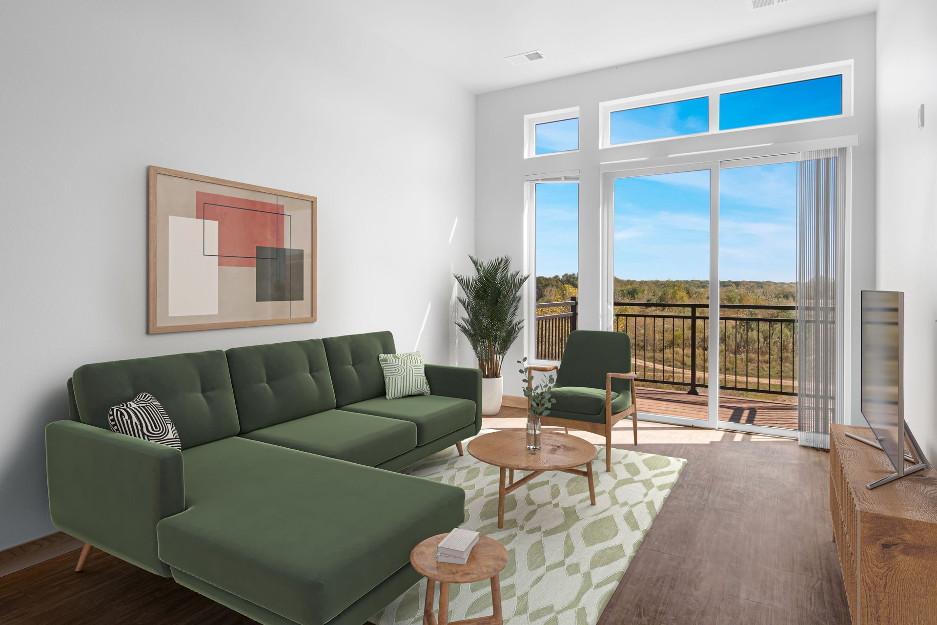 A living room with a green sectional couch and a balcony.