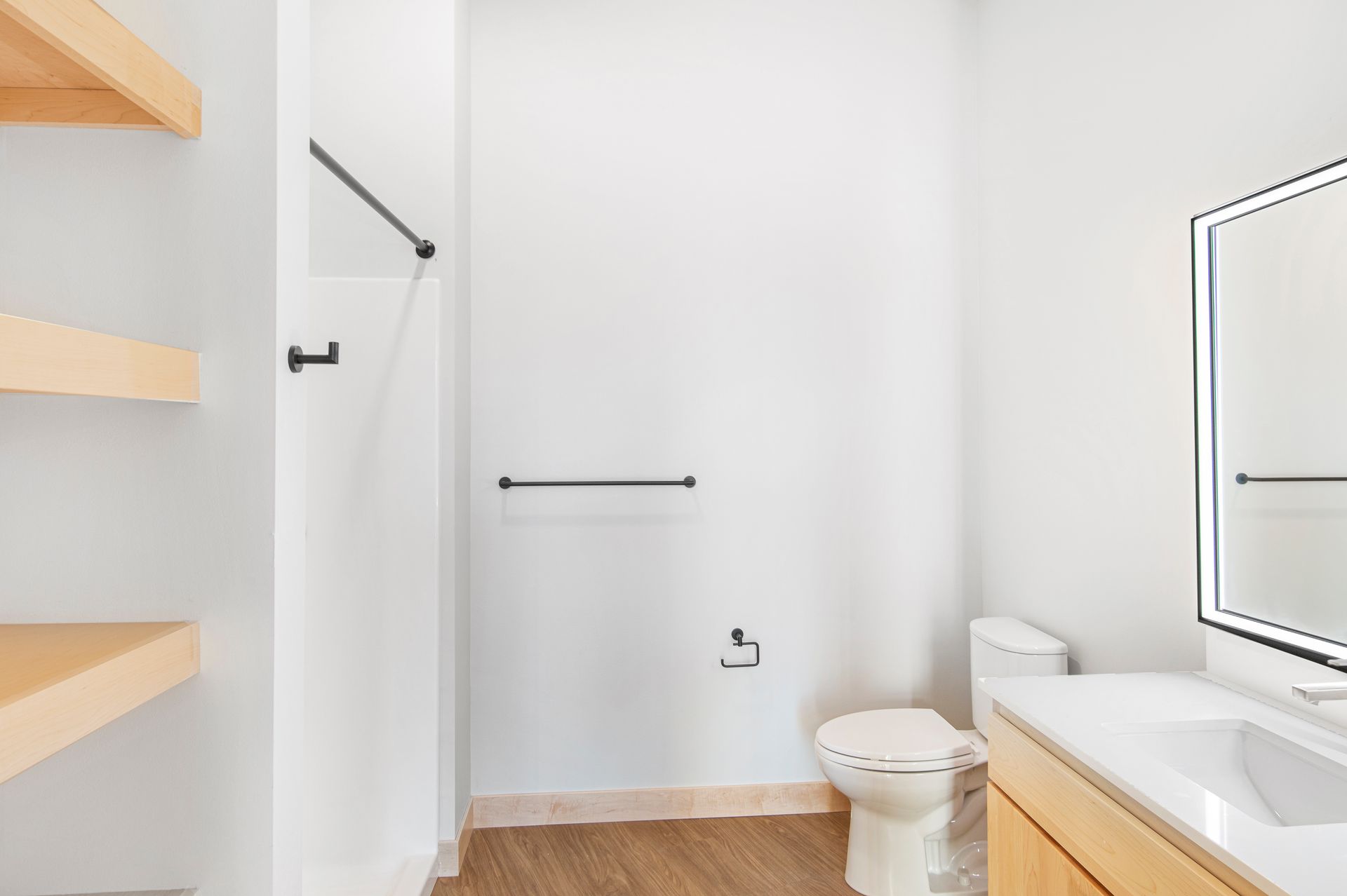 A bathroom with a toilet , sink and mirror.