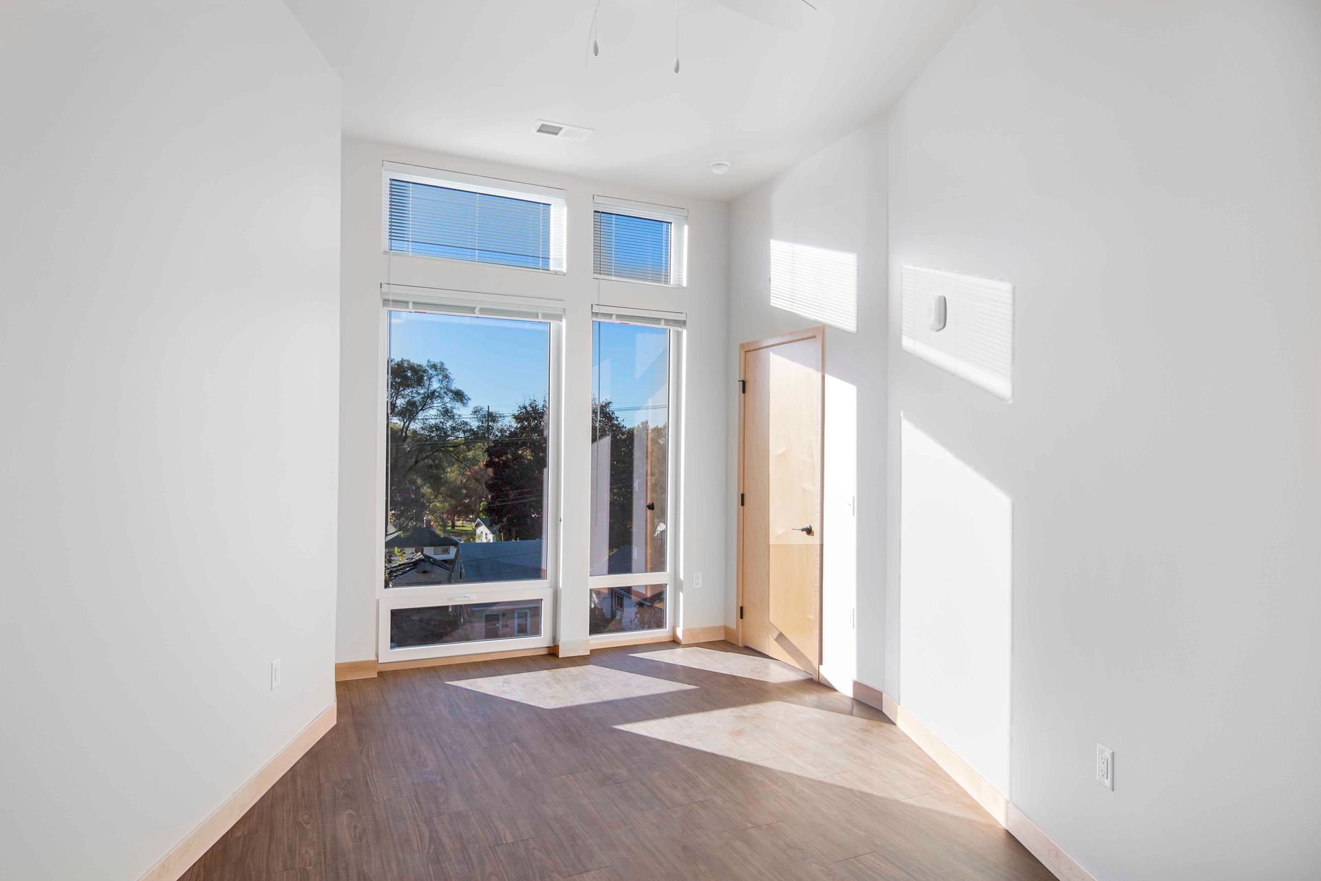 An empty room with a lot of windows and a door.