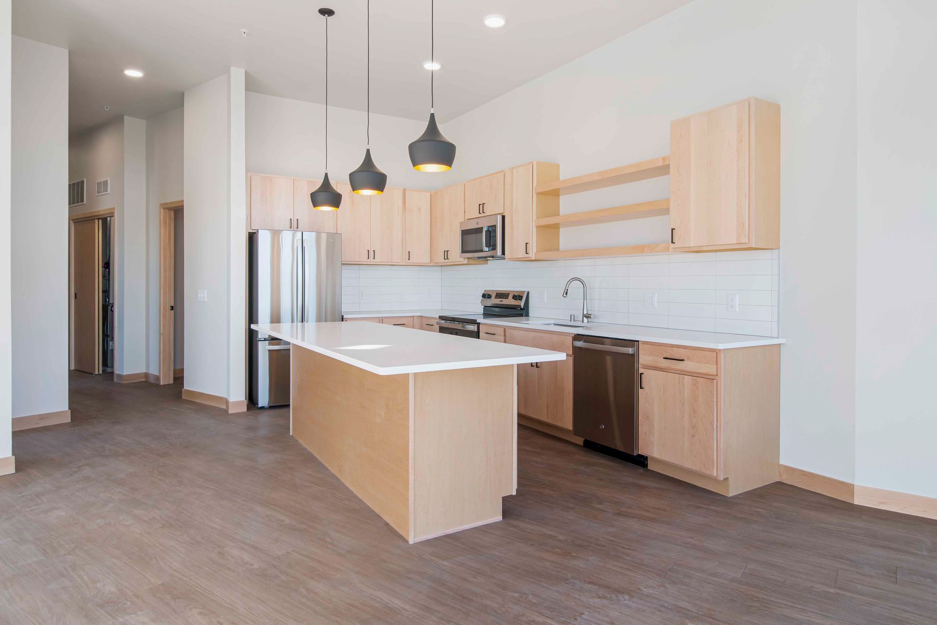 A kitchen with wooden cabinets , stainless steel appliances , and a large island.