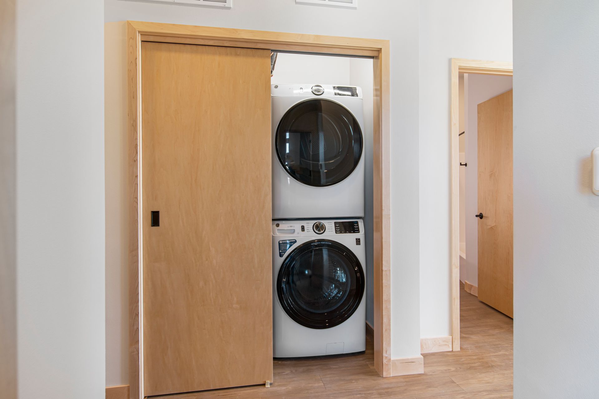 A washer and dryer are stacked on top of each other in a closet.