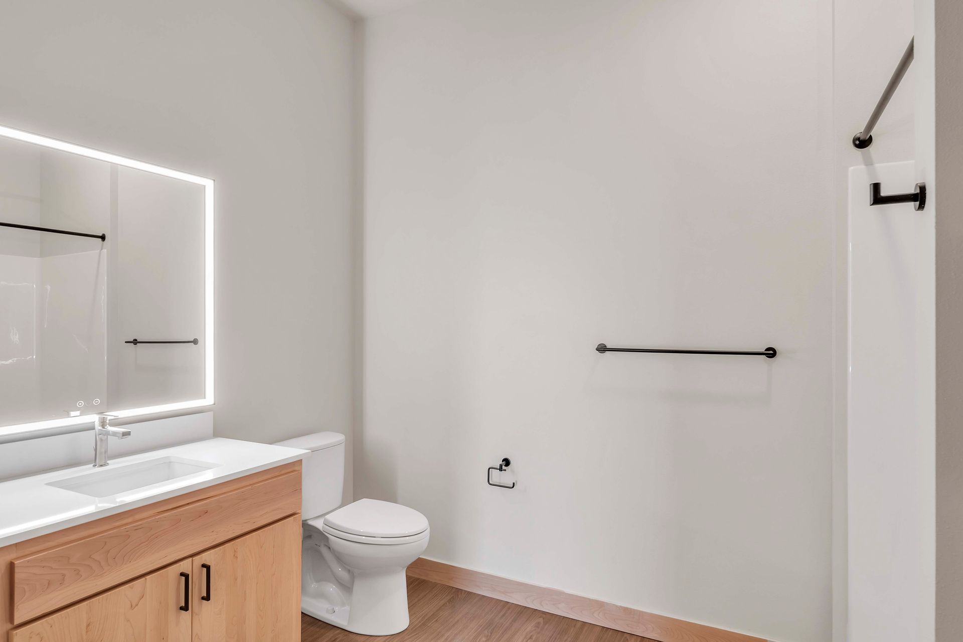 A bathroom with a toilet , sink and mirror.