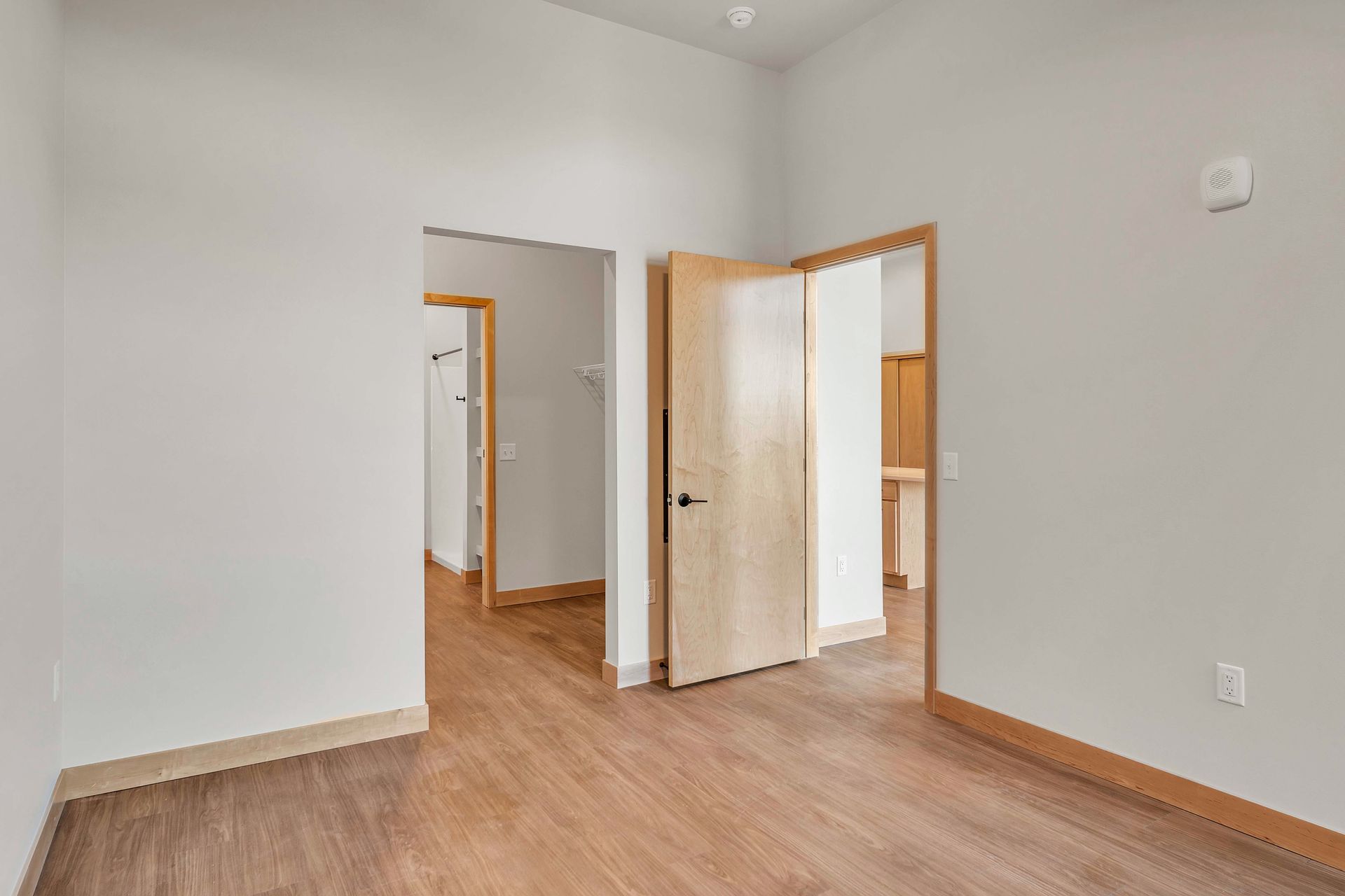 An empty room with hardwood floors and white walls.
