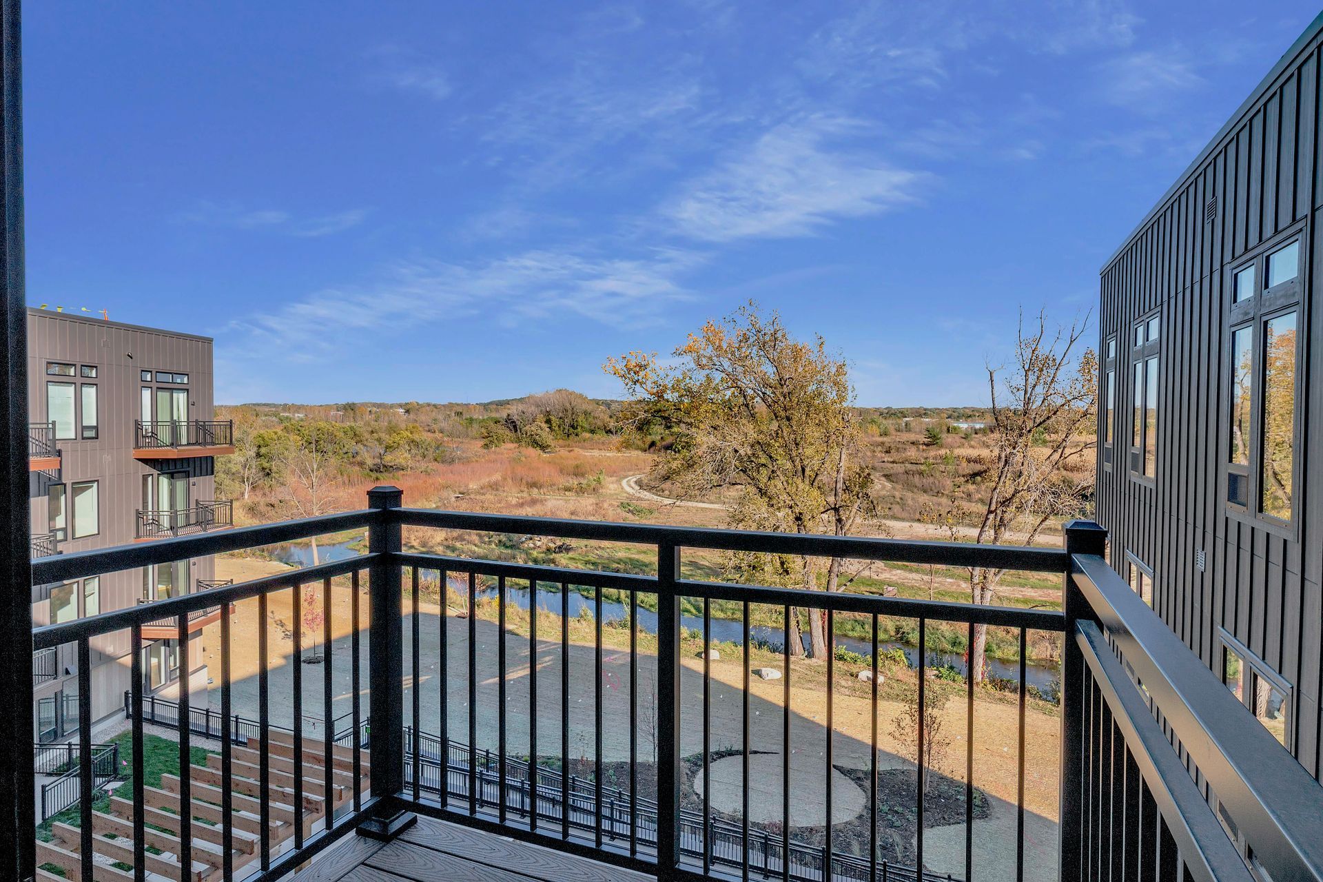 A balcony with a view of a river and trees.