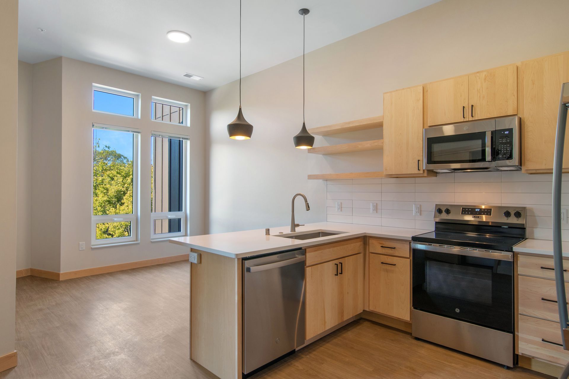 A kitchen with stainless steel appliances and wooden cabinets.