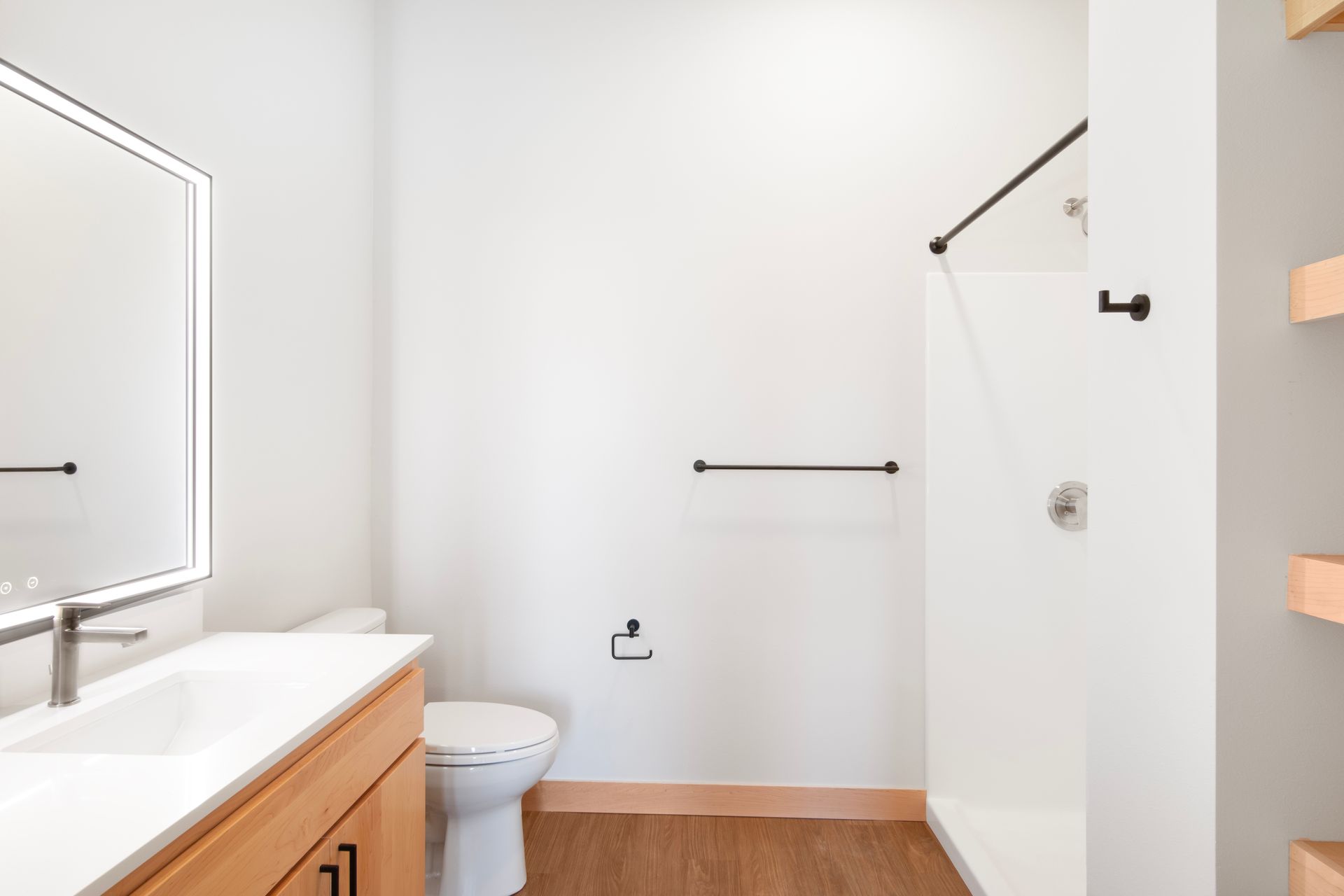 A bathroom with a toilet , sink , mirror and shower.