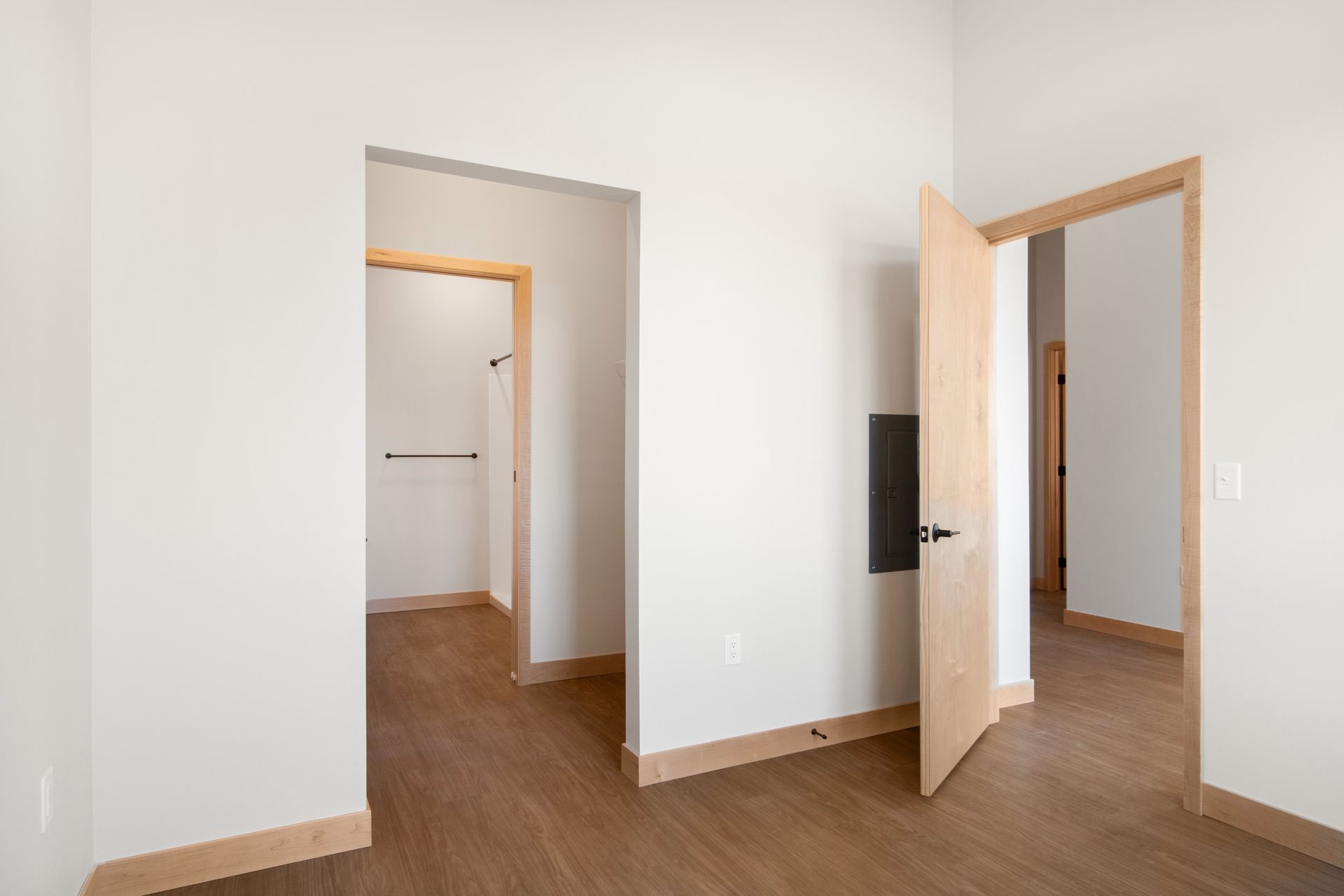 An empty room with wooden floors and white walls.