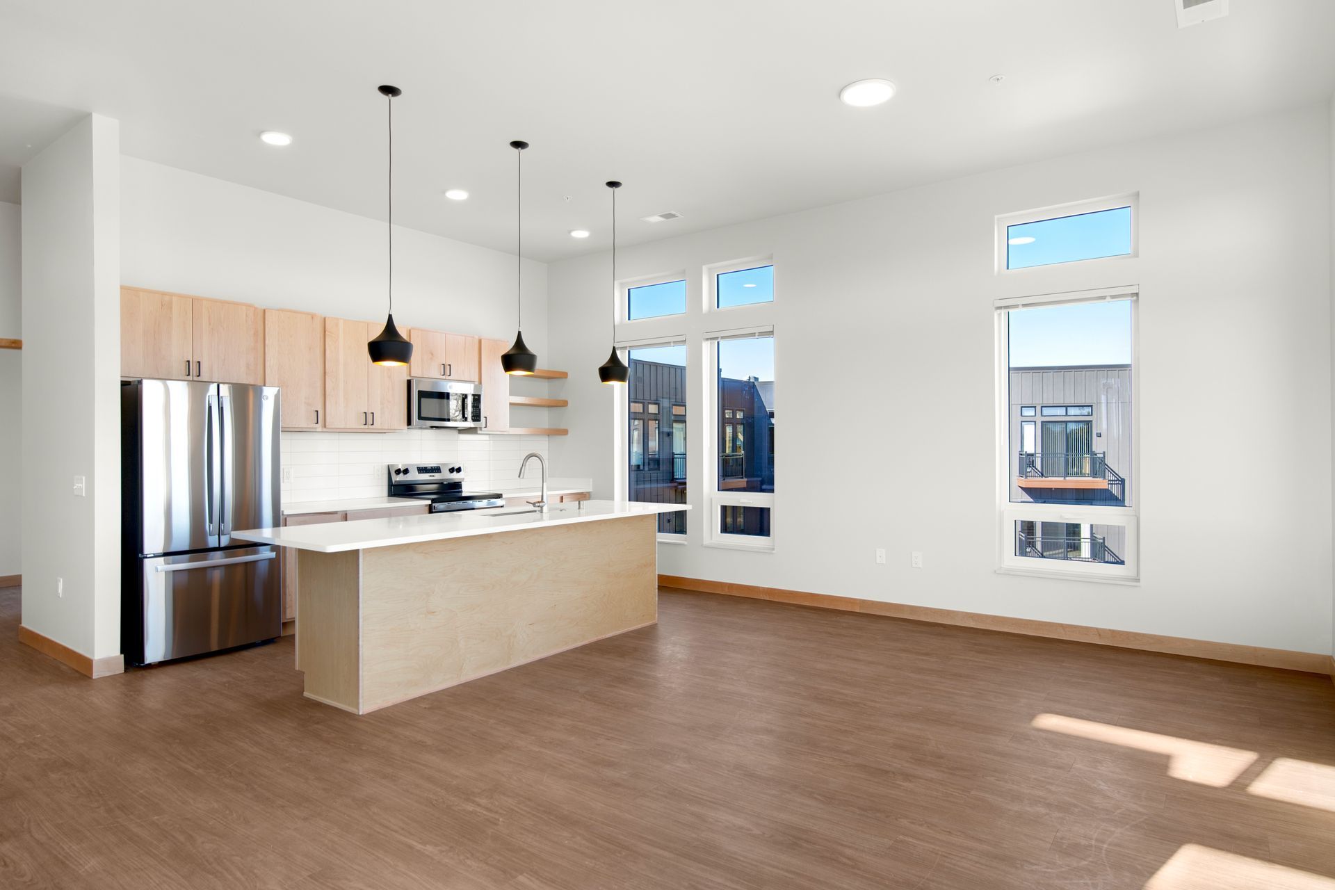 A kitchen with stainless steel appliances and a large island in the middle of the room.