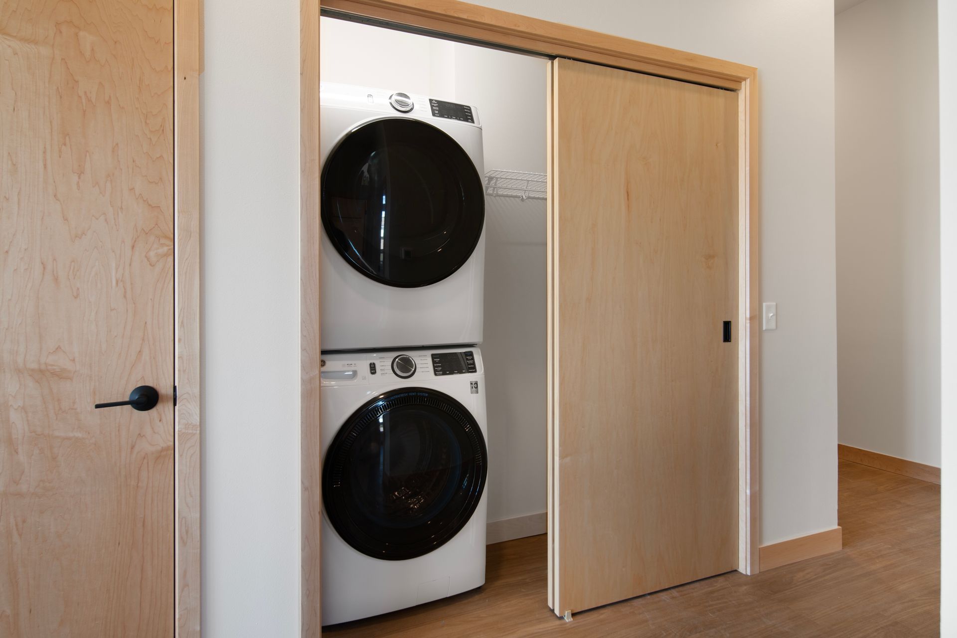 A washer and dryer are stacked on top of each other in a laundry room.