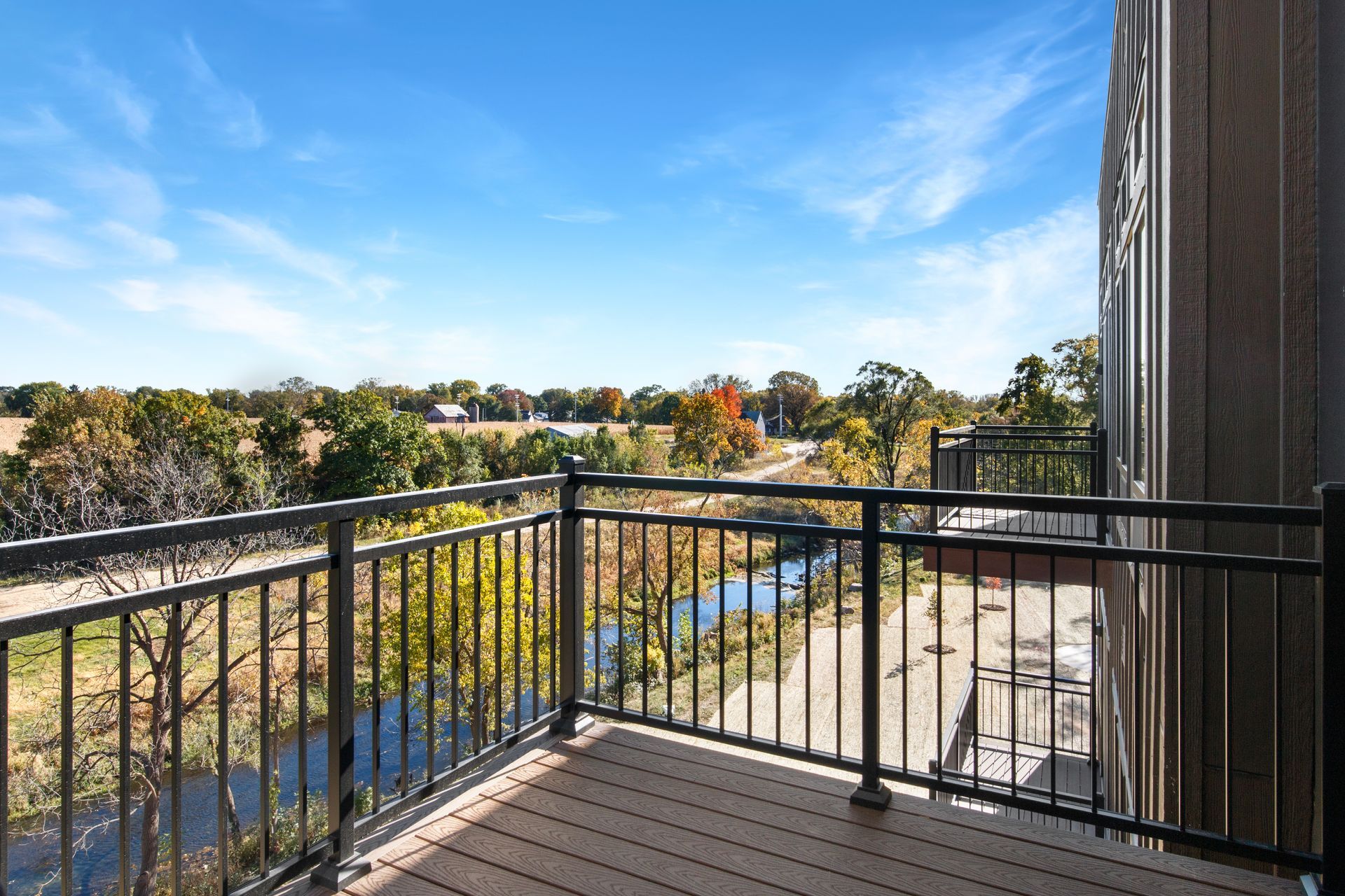 A balcony with a view of a river and trees.