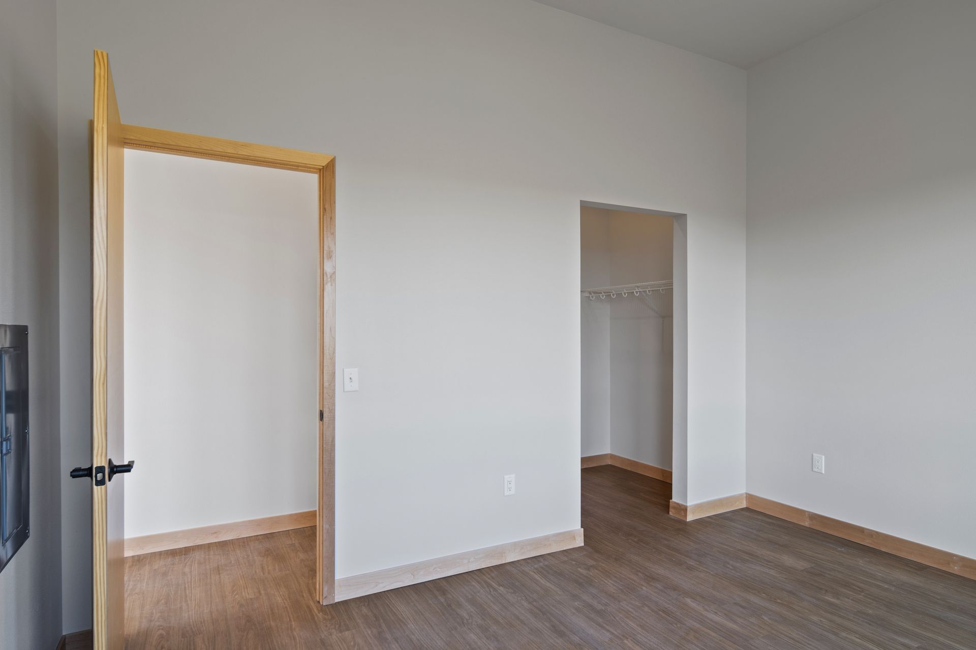 An large room with a lvp flooring and white walls.