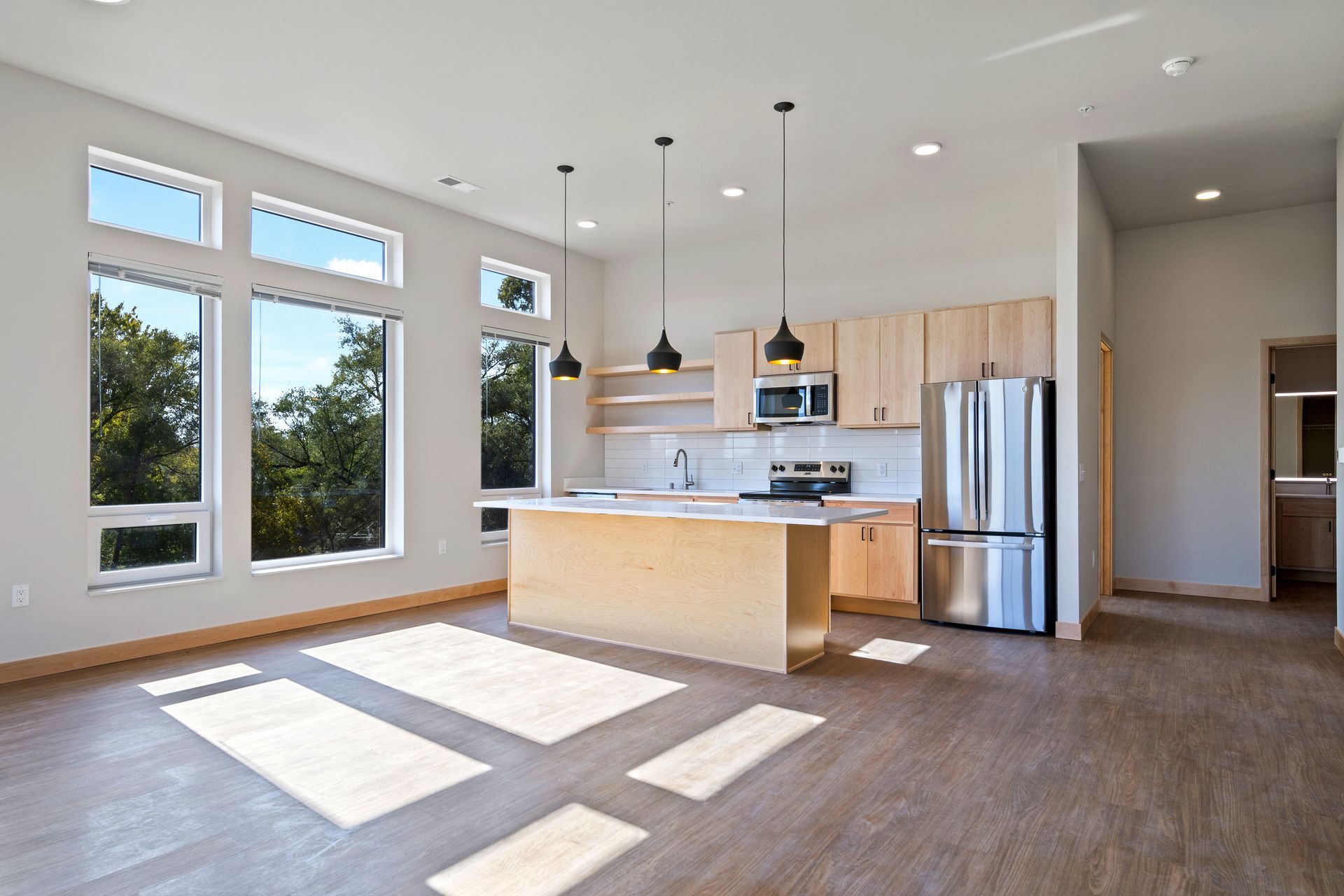An open kitchen with stainless steel appliances and wooden cabinets.